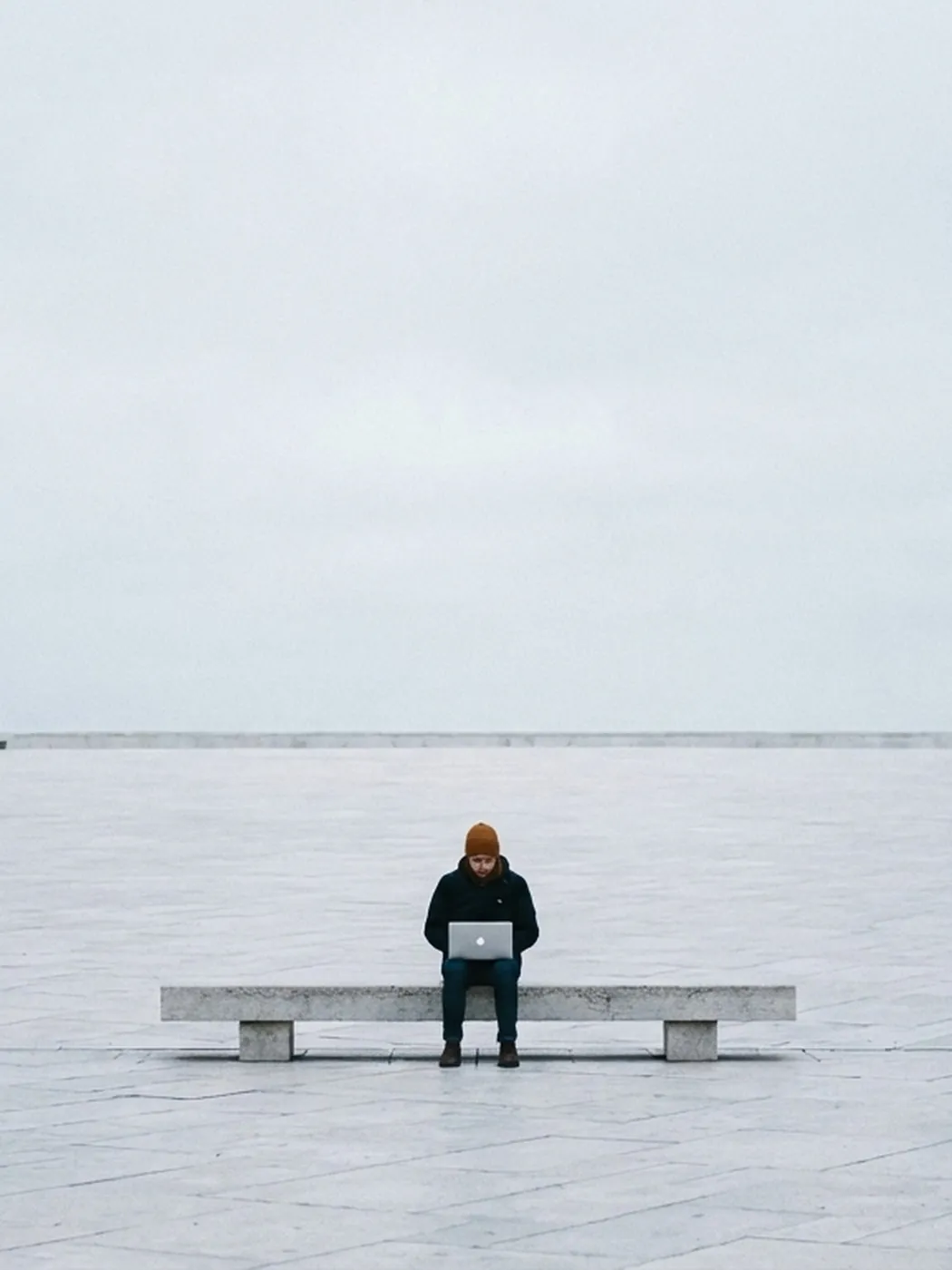 Person on a bench with a laptop