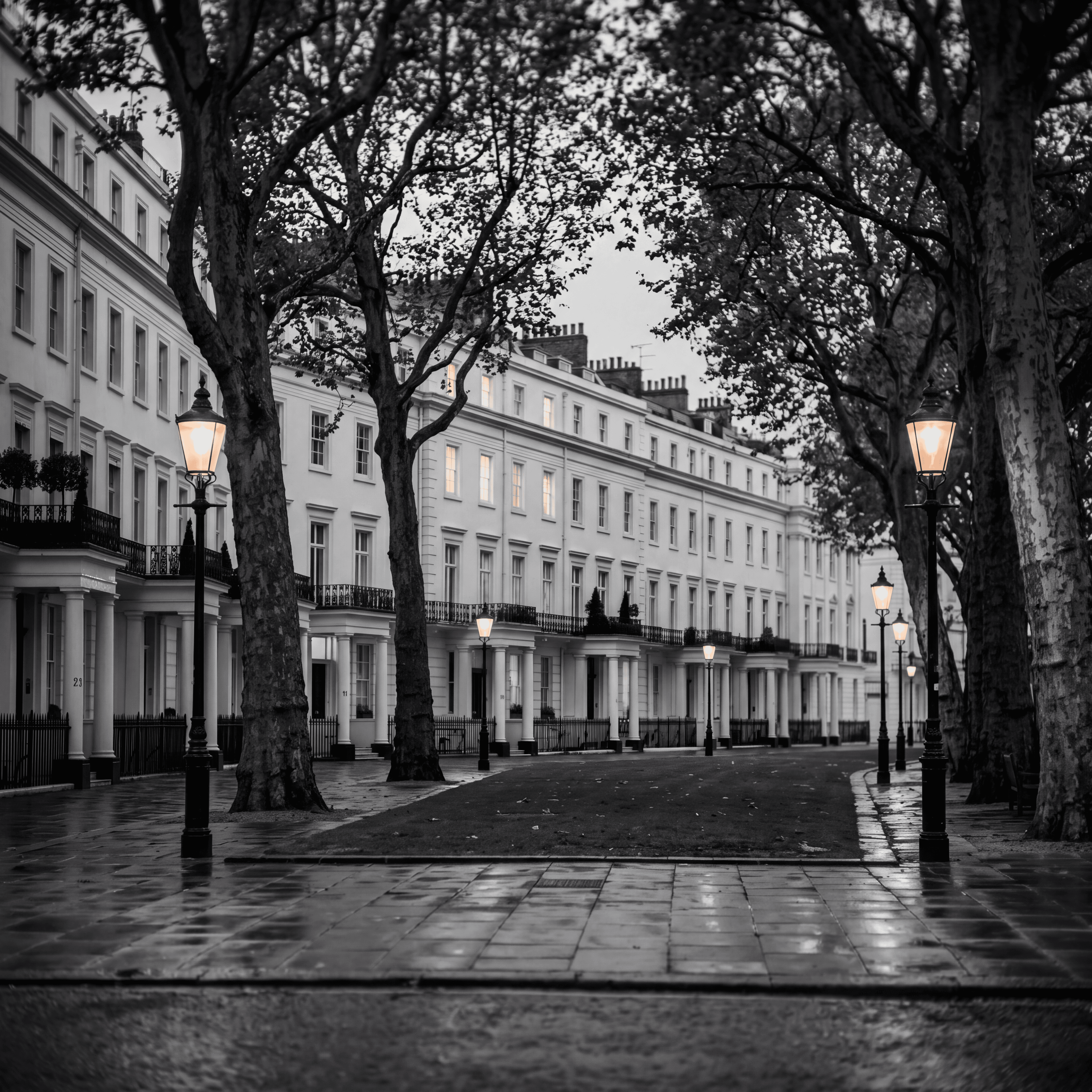 Eaton Square in Belgravia at dusk with white stucco mansions and illuminated windows, illustrating the concentration of London super-prime sales in three postcodes, monochrome editorial photograph