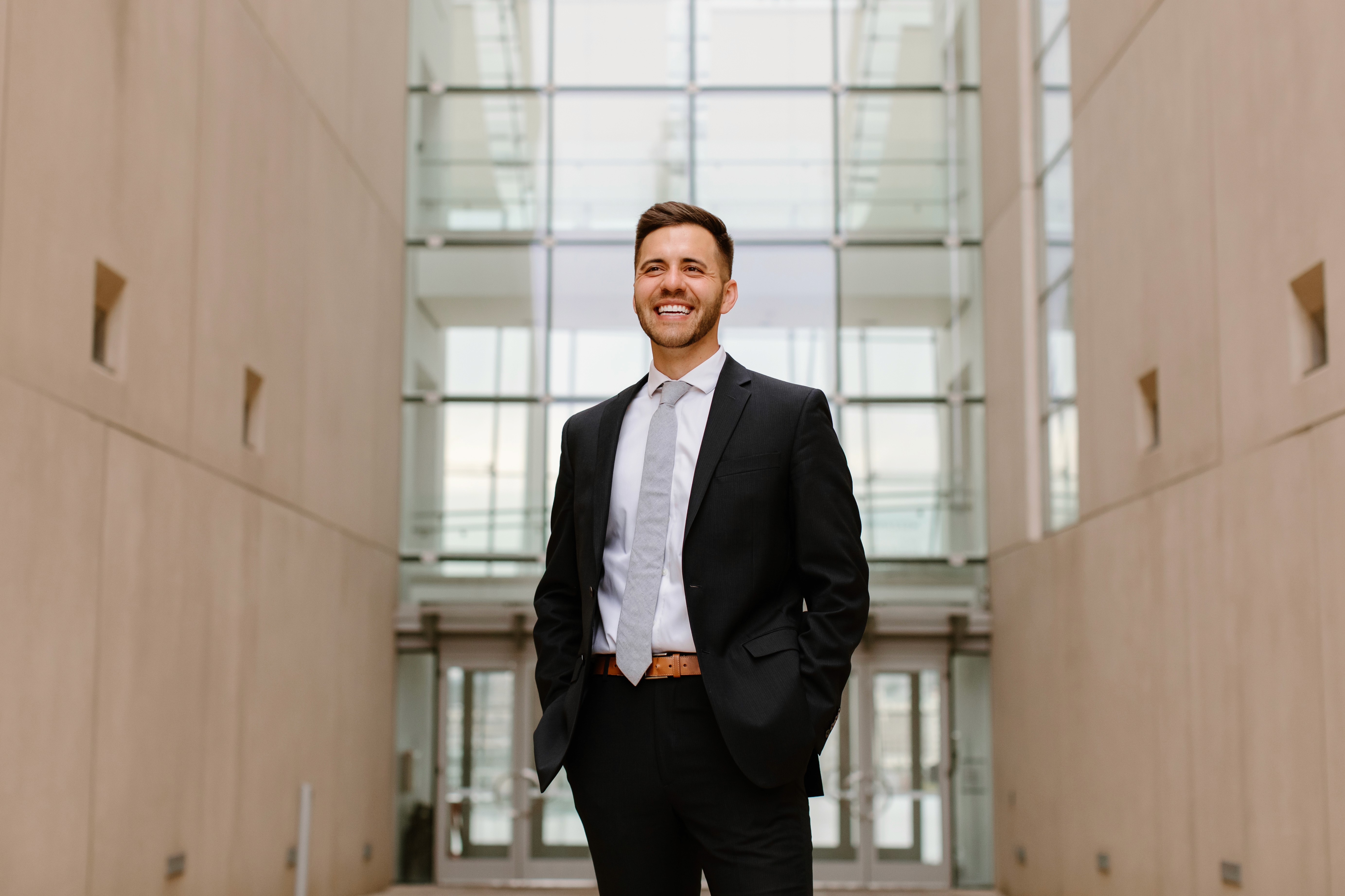Close-up of a scientist holding a tray of petri dishes with purple cultures, wearing gloves and safety gear.