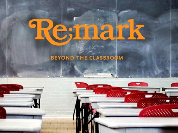 An orange square graphic with the text "Re mark" is superimposed on a classroom scene featuring white desks with red chairs arranged in rows facing a chalkboard.