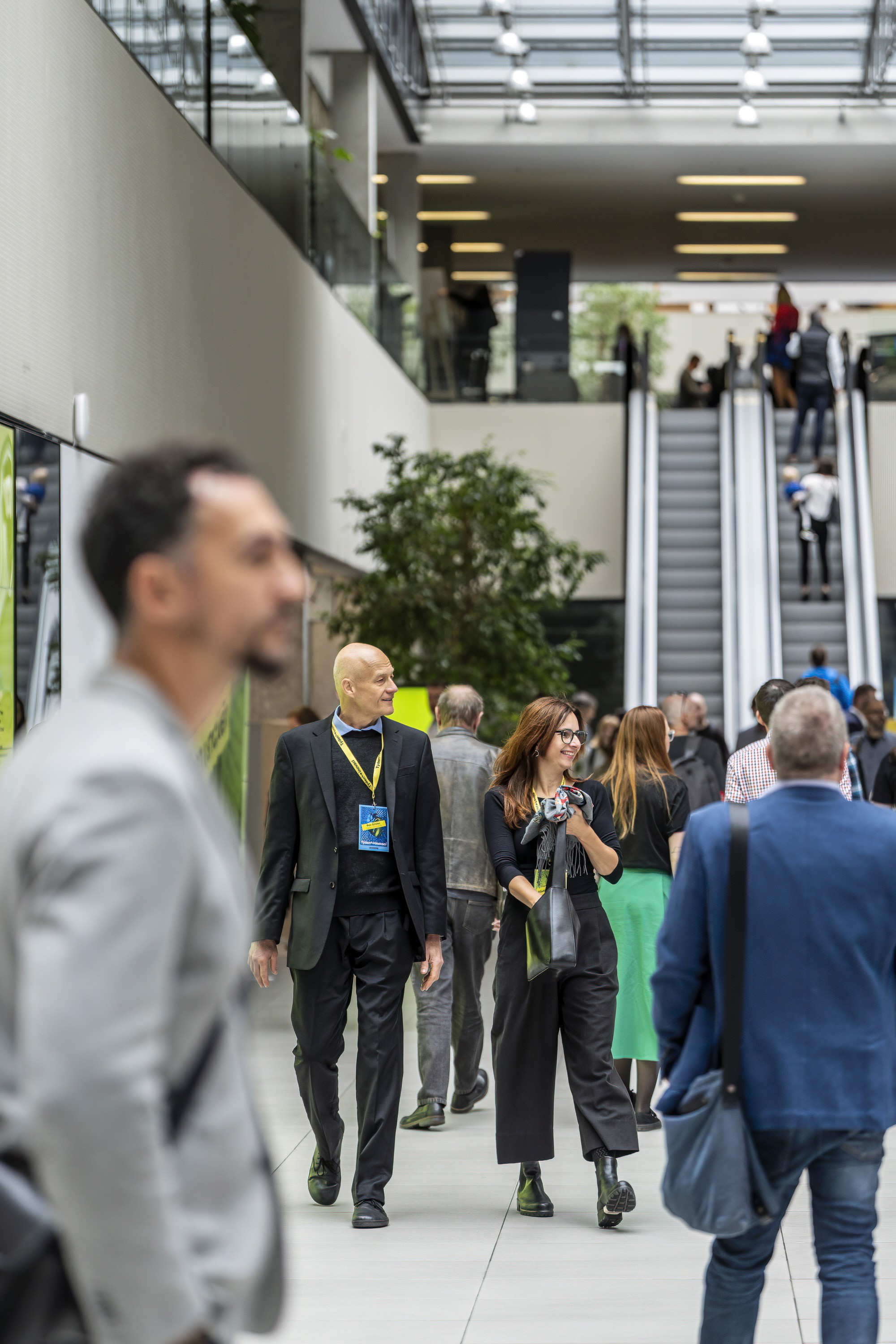 Conference attendees walking through a venue during a large business event.
