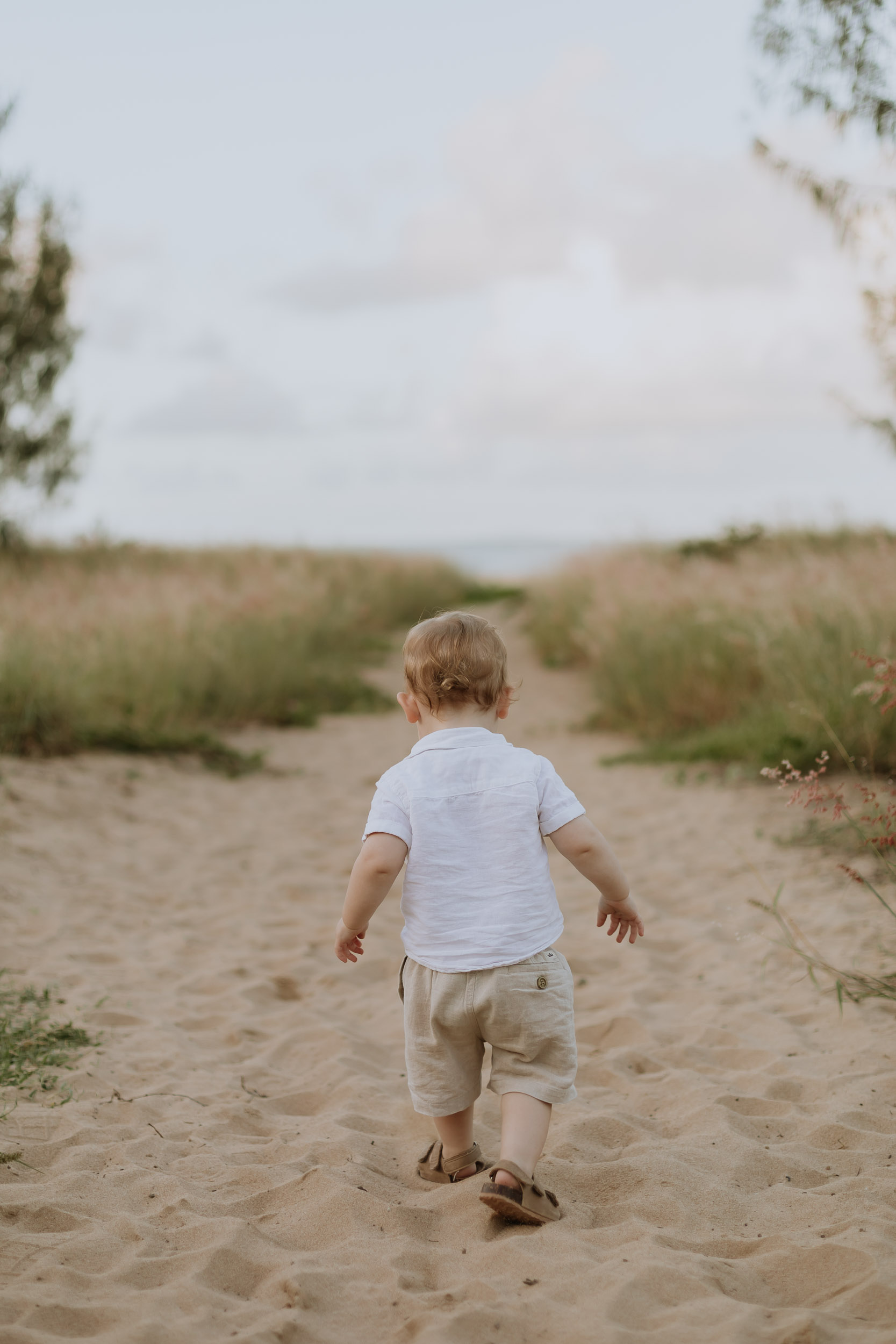 Child running towards the beach in lifestyle family photoshoot Mackay