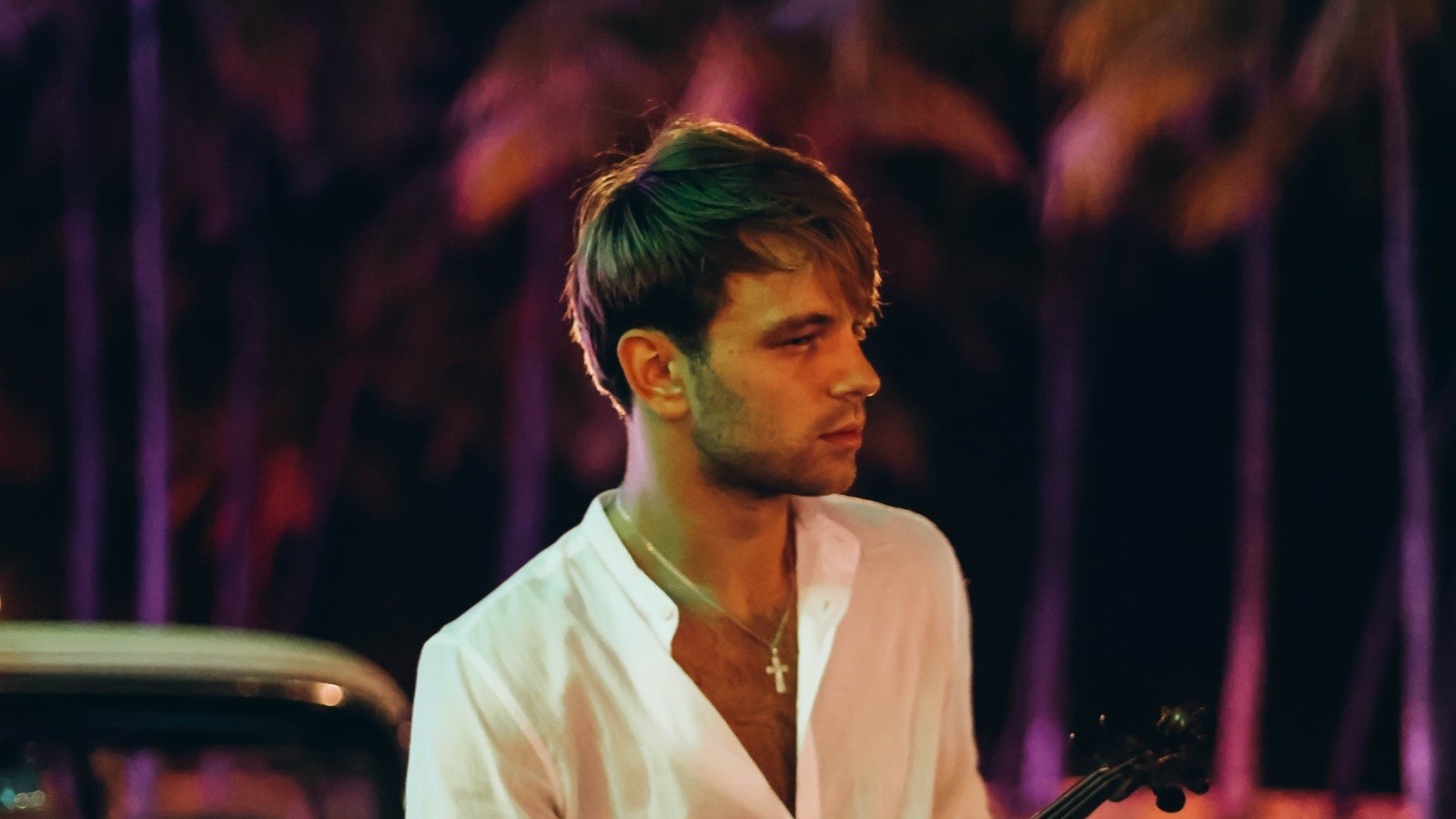 Kostia Lucky with violin beside a vintage car in Miami at night