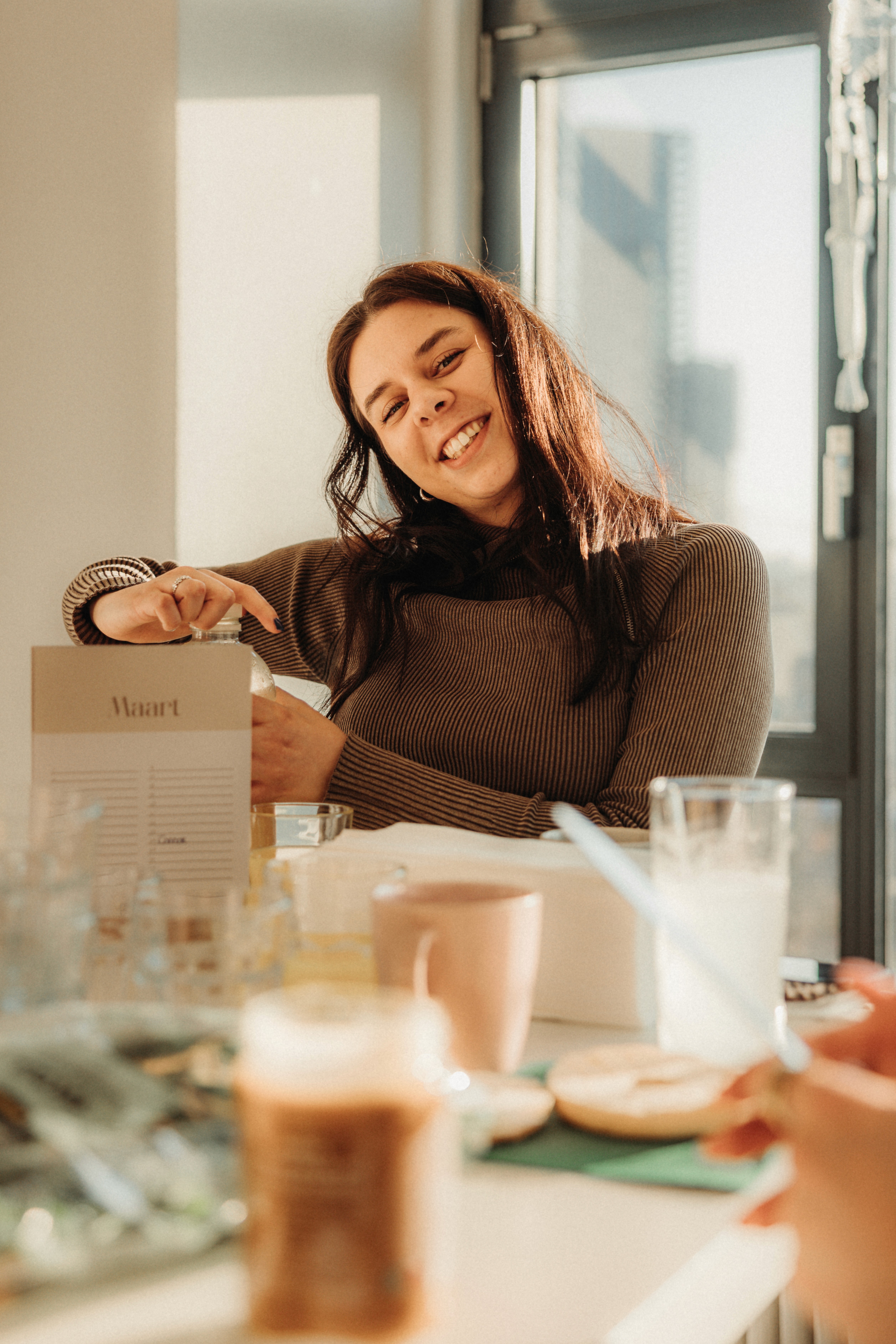 Four people gathered in a bright room, working together at a laptop on a small table.