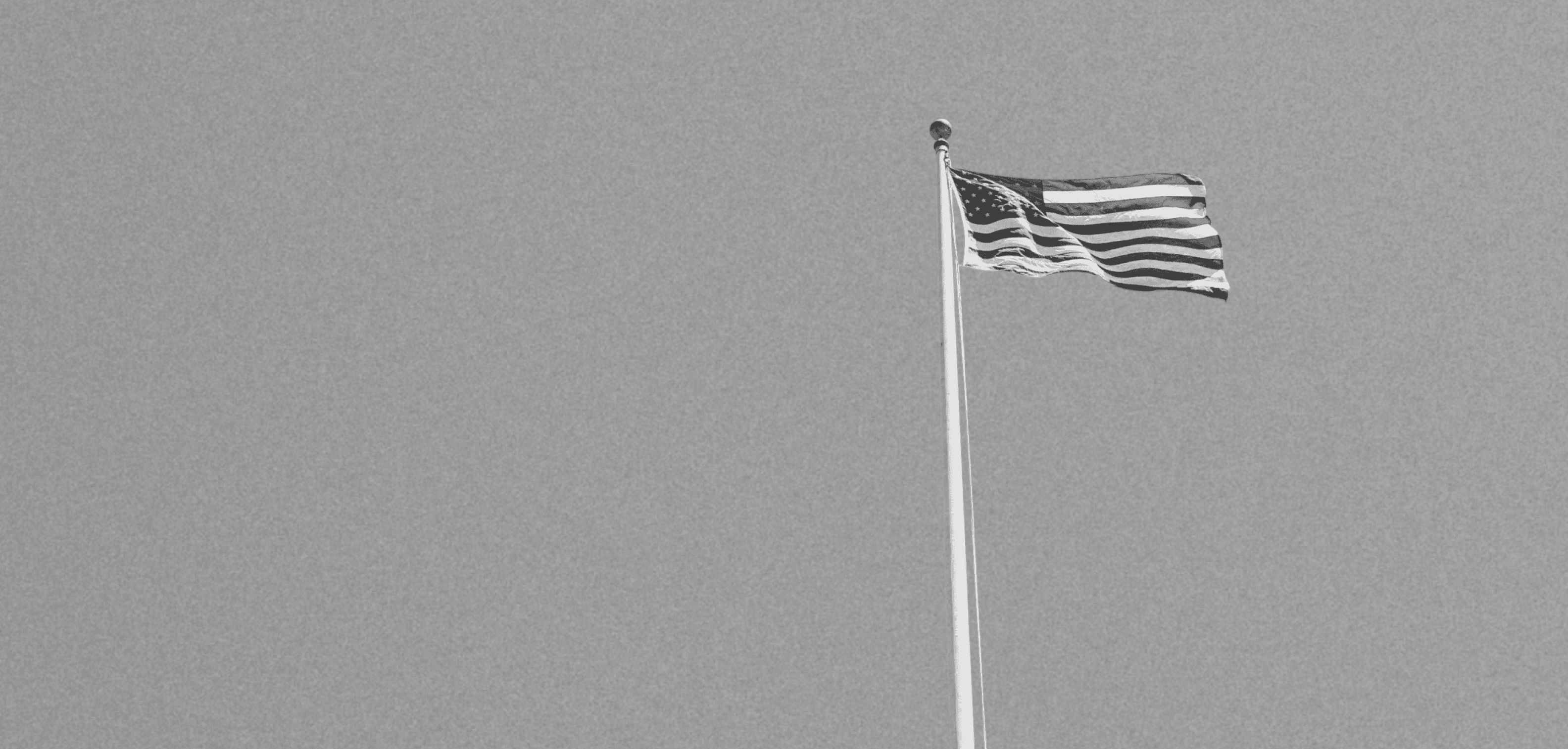 black and white image of american flag in the sky