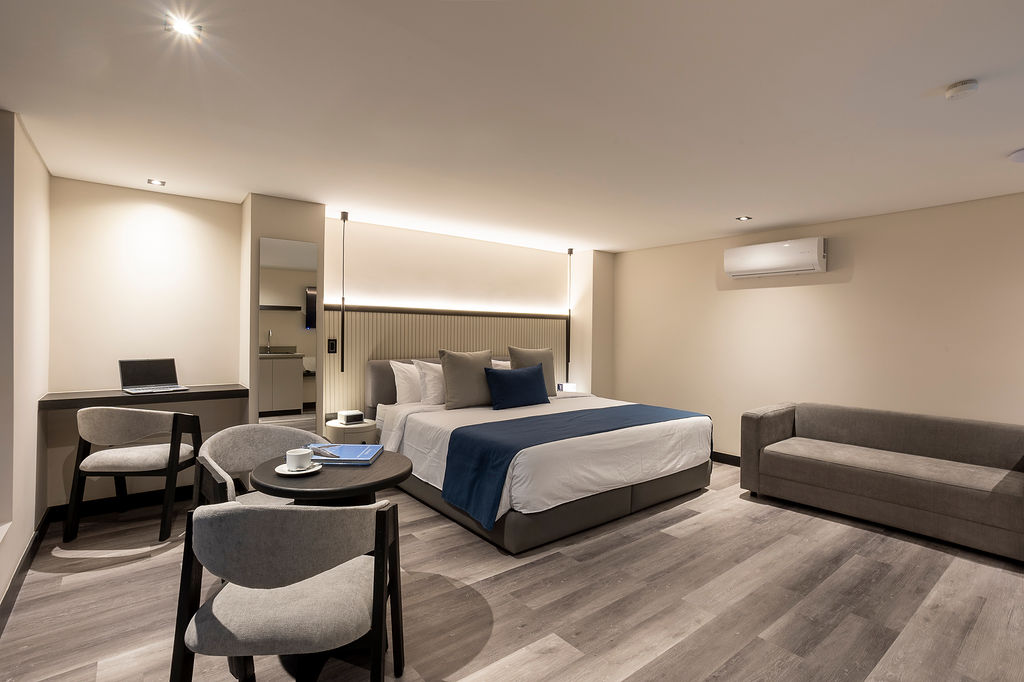 Habitación de lujo con cama king Medellín en Altus Hotel, con ventanales insonorizados y diseño elegante en Laureles.