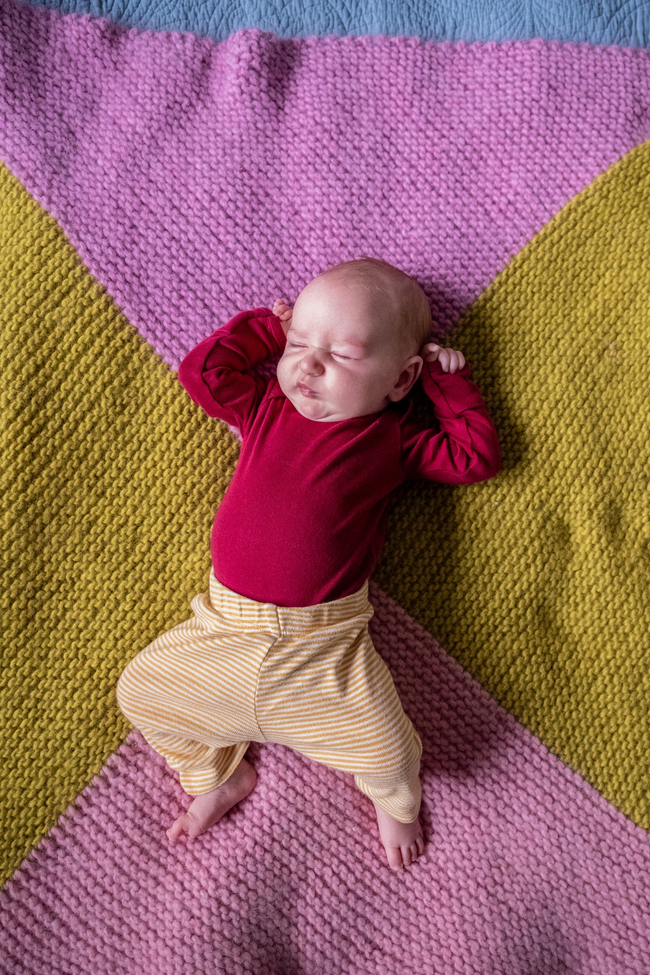 baby-laying-on-pink-and-yellow-knitted-blanket-katt-jones-photography