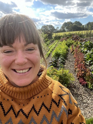 Anne foran bedene i køkkenhaven.