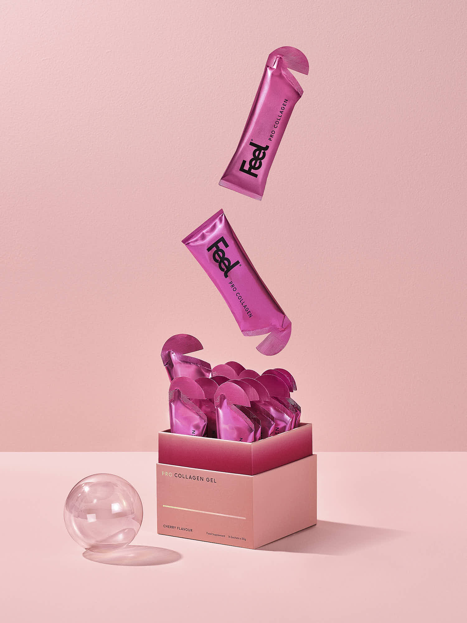 A pink storage box with various pink tubes and containers floating above it against a soft pink background.