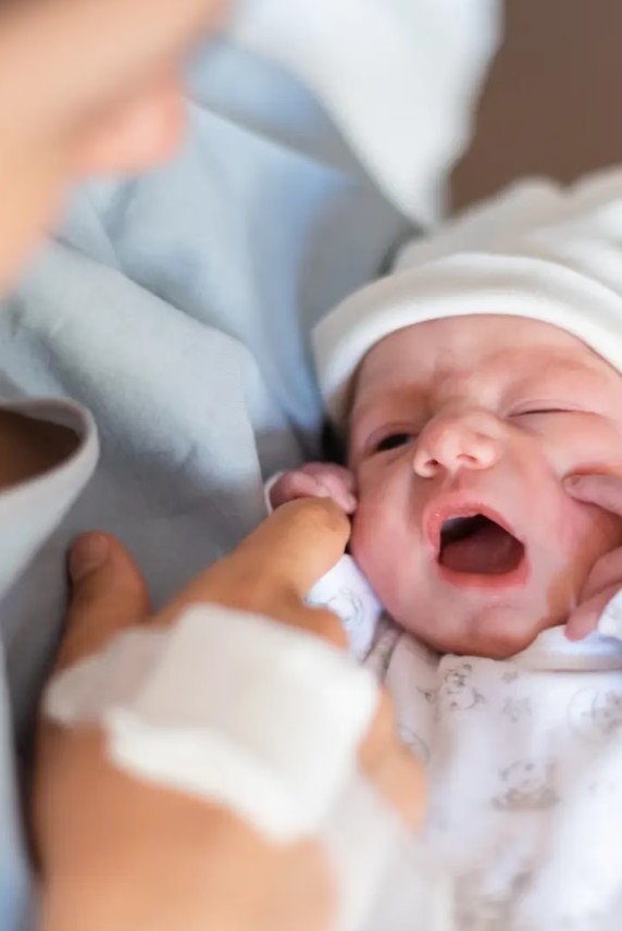 Mother cradling her newborn baby for a fresh 48 photoshoot.