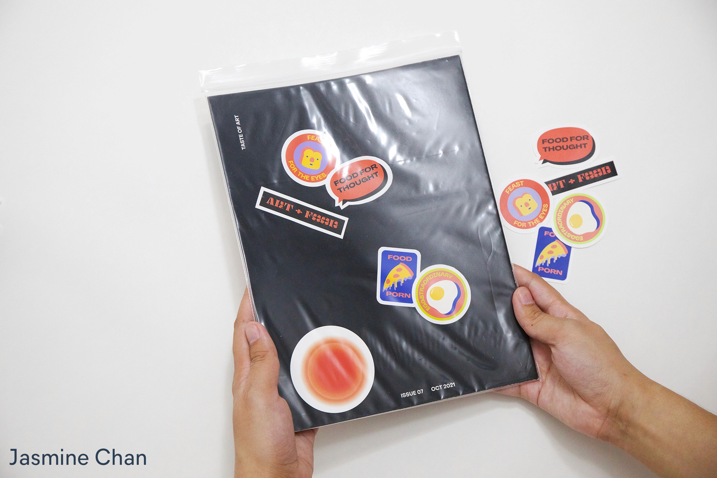 Hands holding Magazine inside a plastic by Jasmine Chan