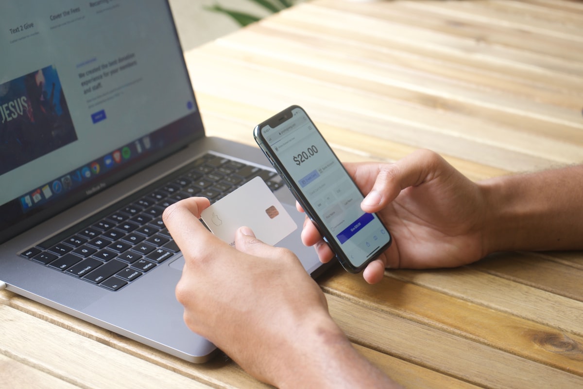 Booking a hotel on a laptop with a rewards credit card in hand