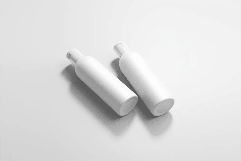 Cosmetic bottle mockup featuring two 500ml bottles on a light gray background. One bottle is black with a black cap, and the other is red with a white cap, both showcasing minimalist designs.