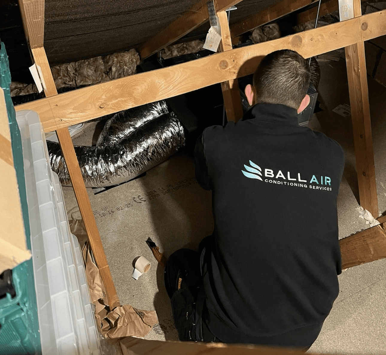 A serene outdoor lounge area with two chairs surrounded by lush greenery and natural light streaming in.