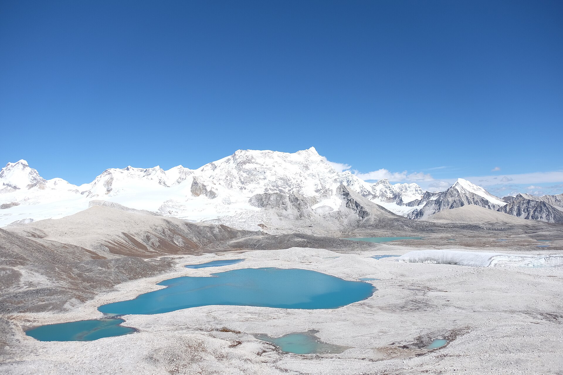 Gangkhar Puensum and its snowfields seen from Gophu La, with turquoise glacial lakes below