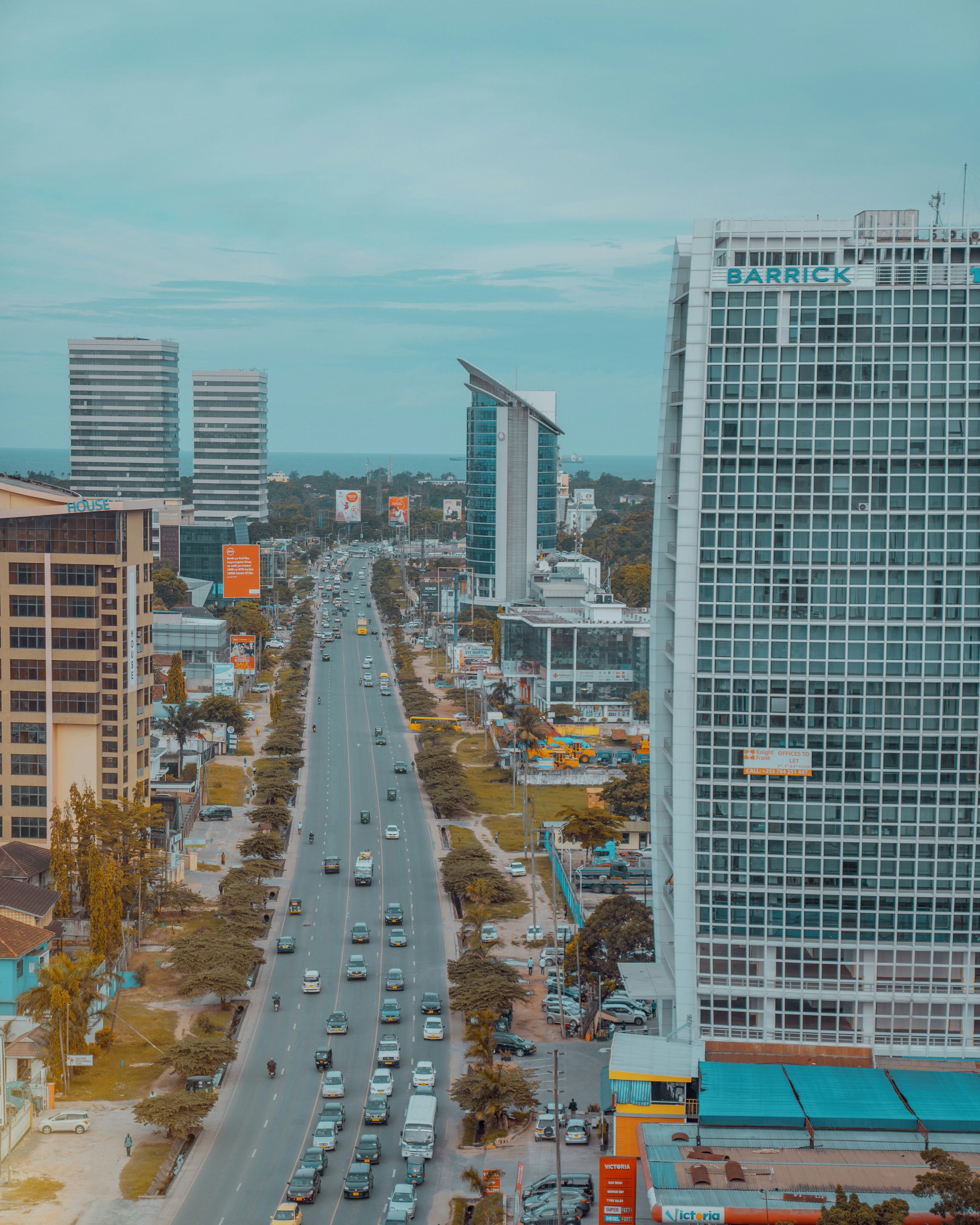 cars on road near high rise buildings during daytime