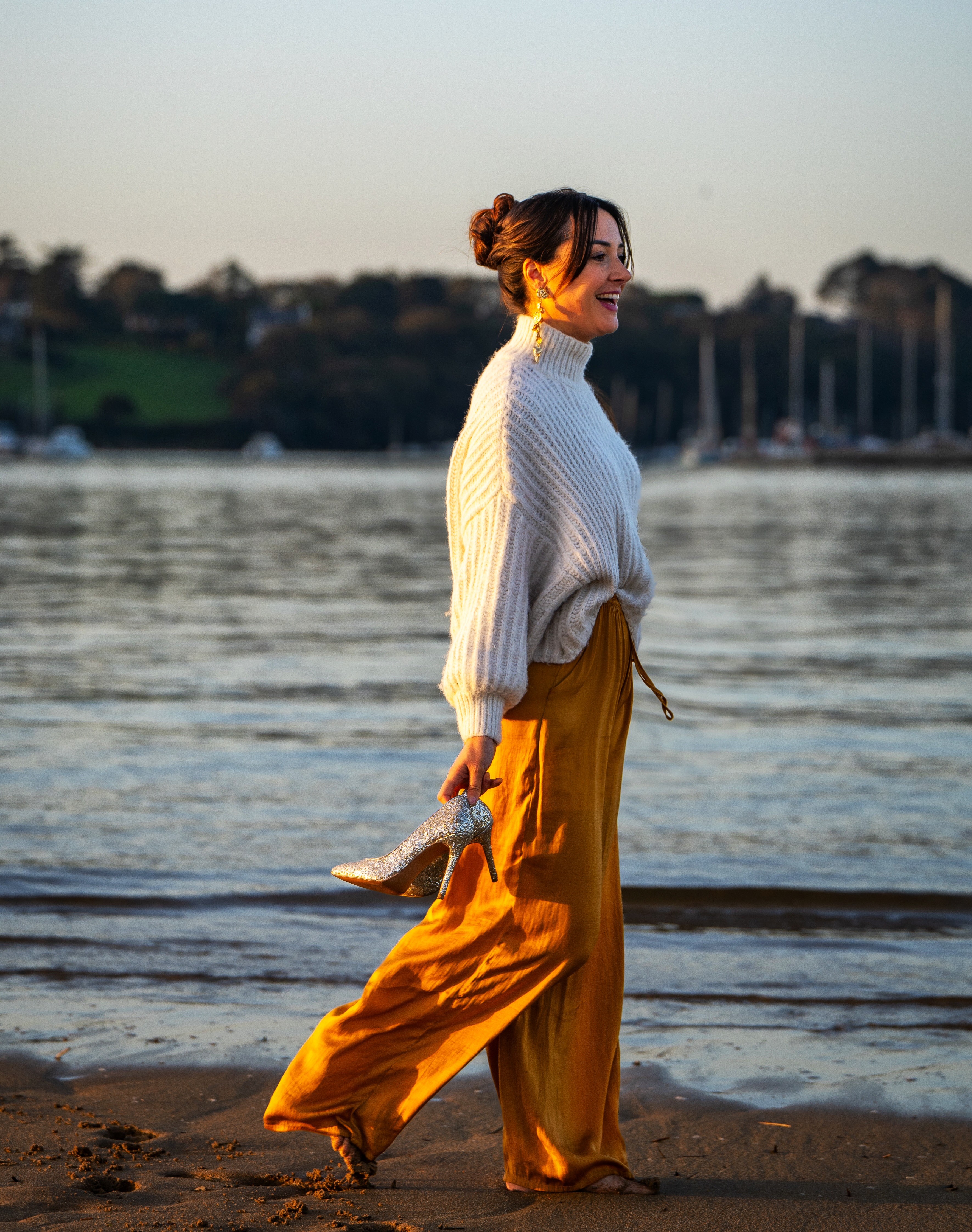 Professeure de yoga se promenant au bord de l'eau au coucher de soleil