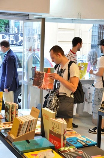 A photo of a man checking a book in a library.