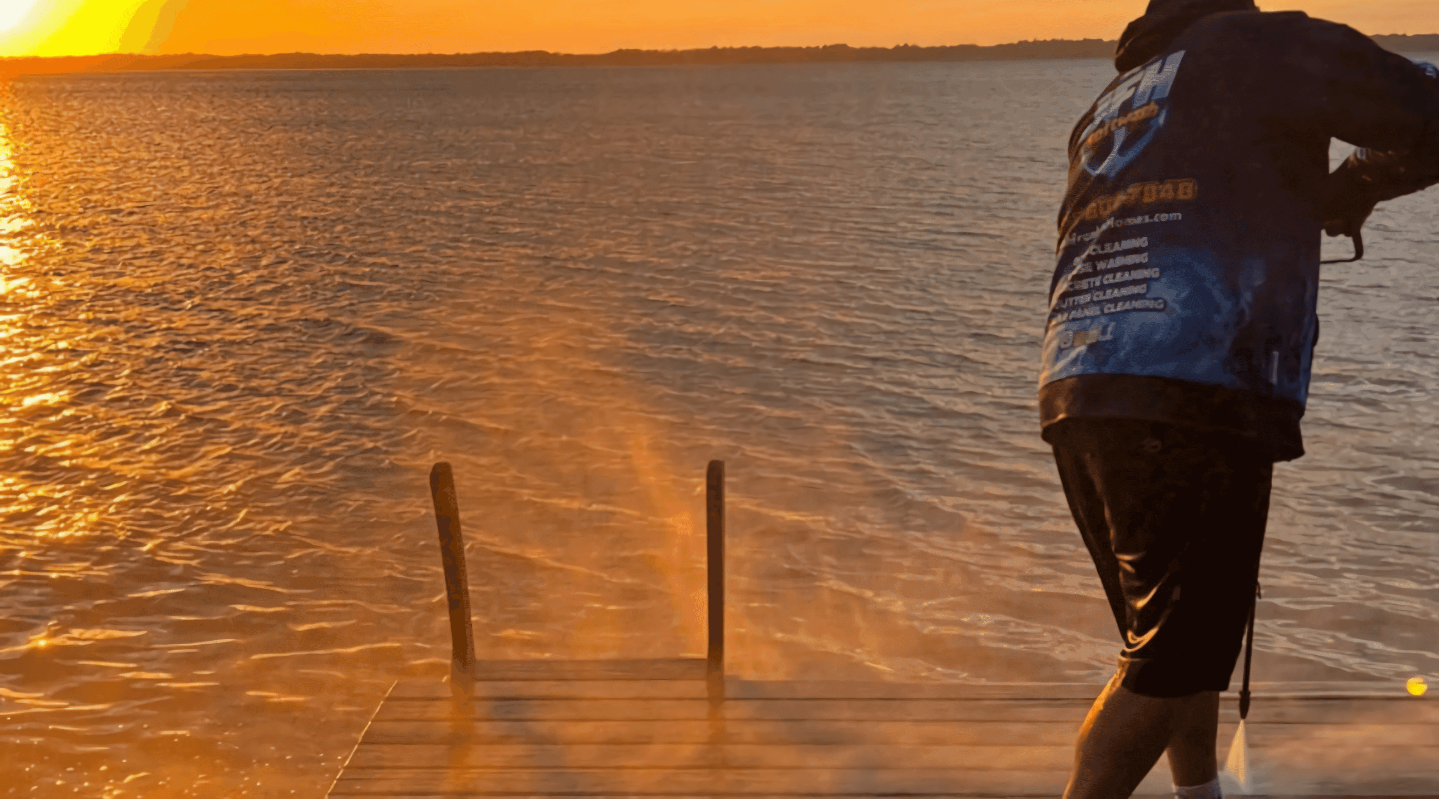 Image of a guy pressure washing a dock