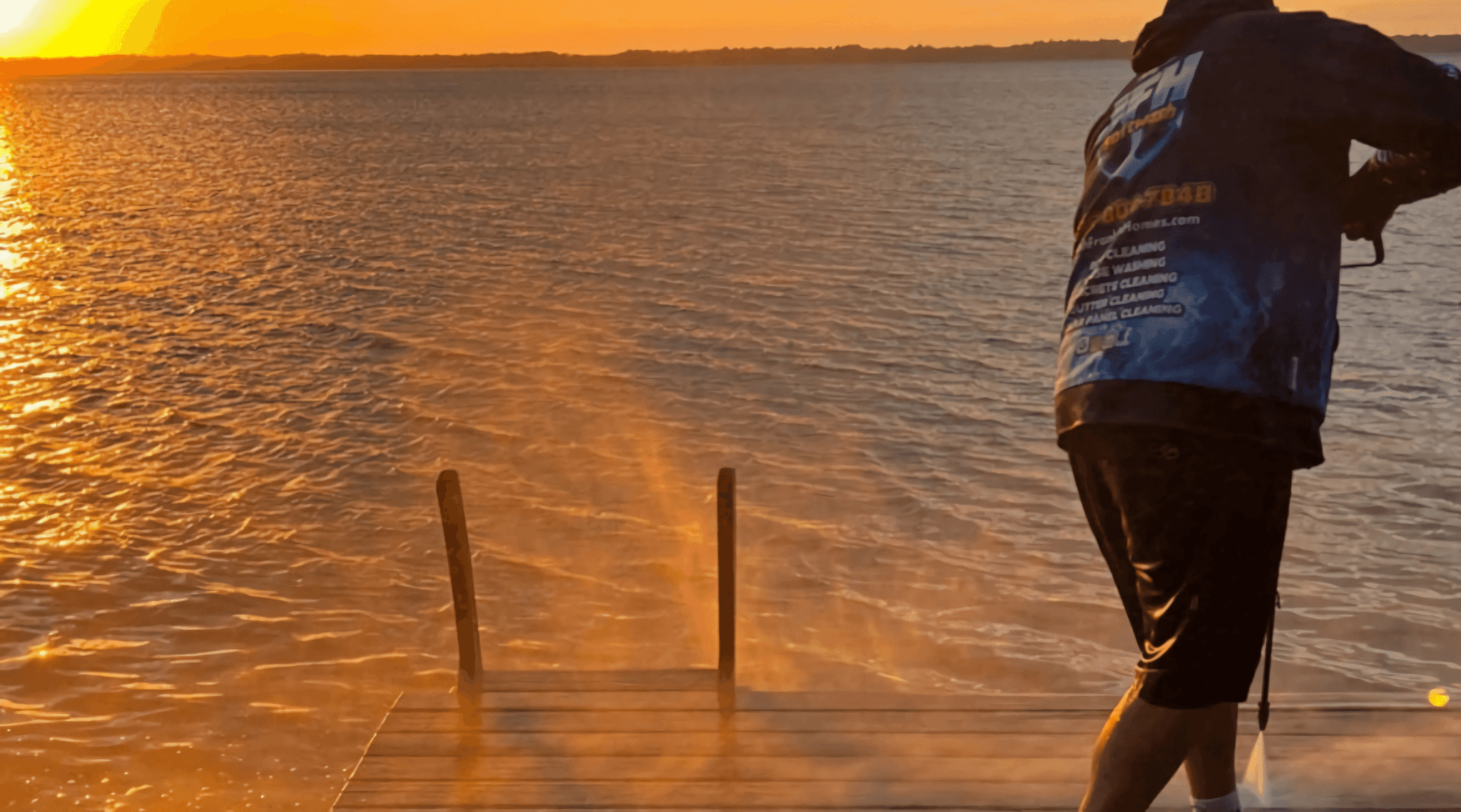 Image of a guy pressure washing a dock