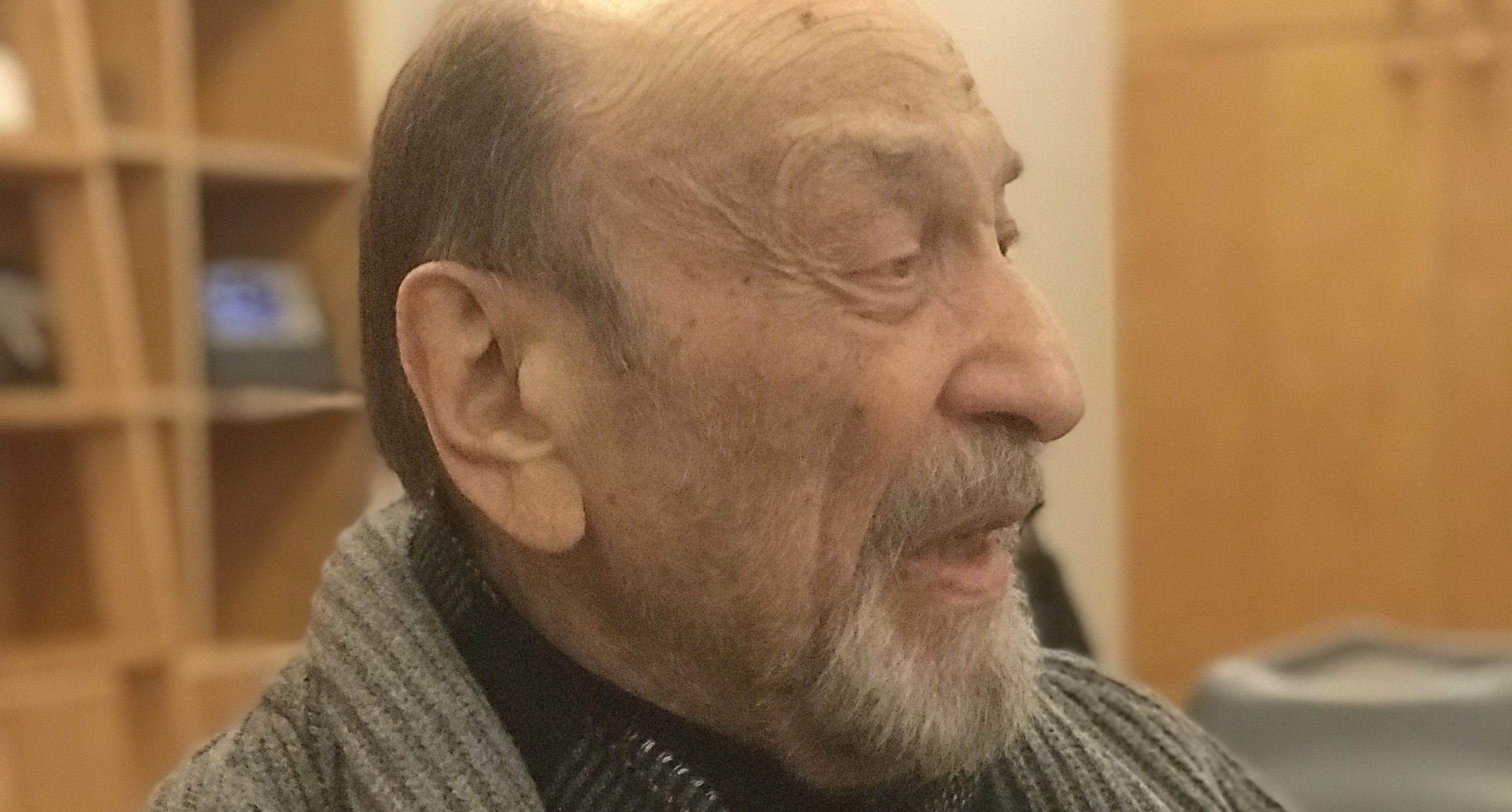 A photo of a man wearing a grey sweater.