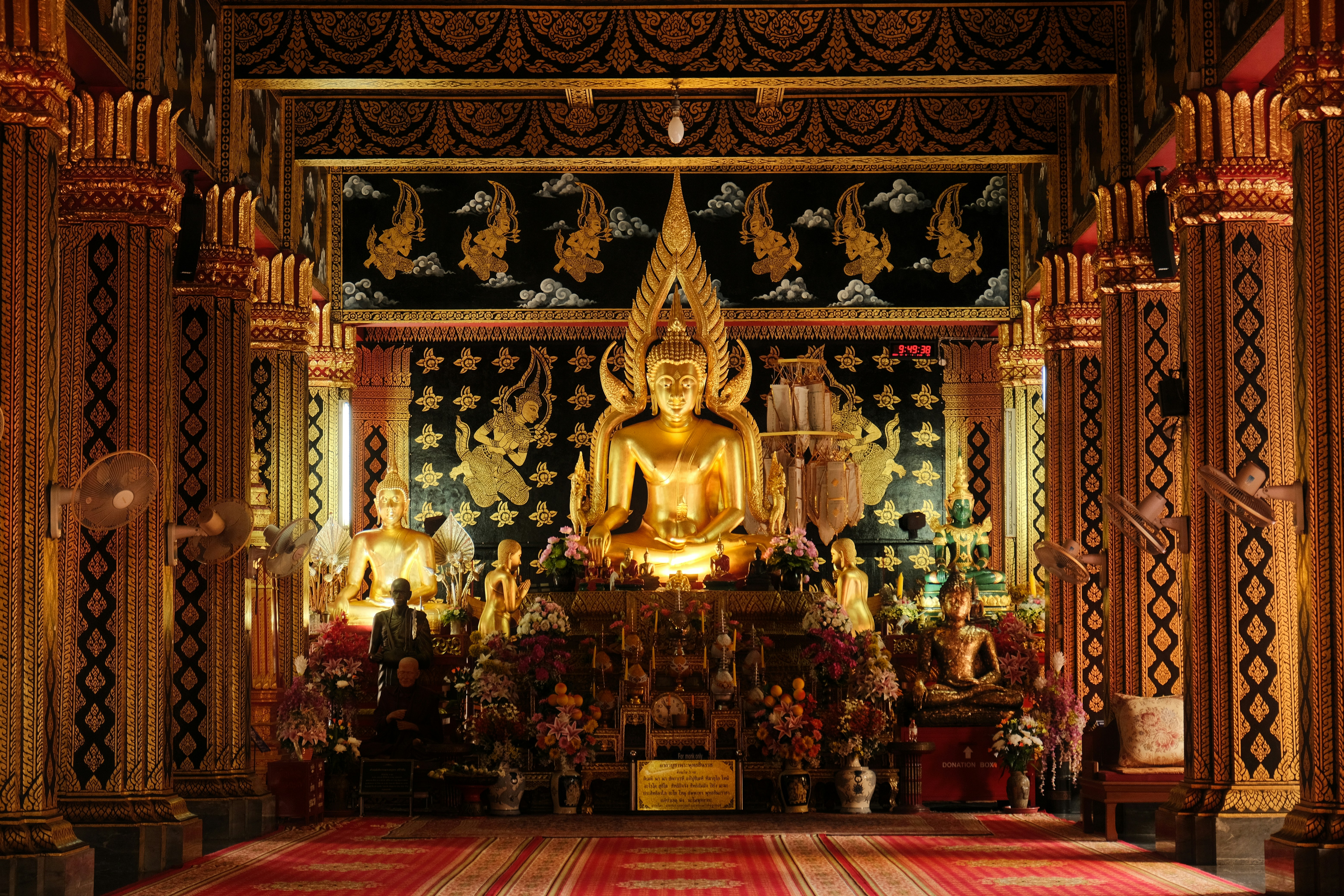 A large golden buddha statue sitting inside of a building