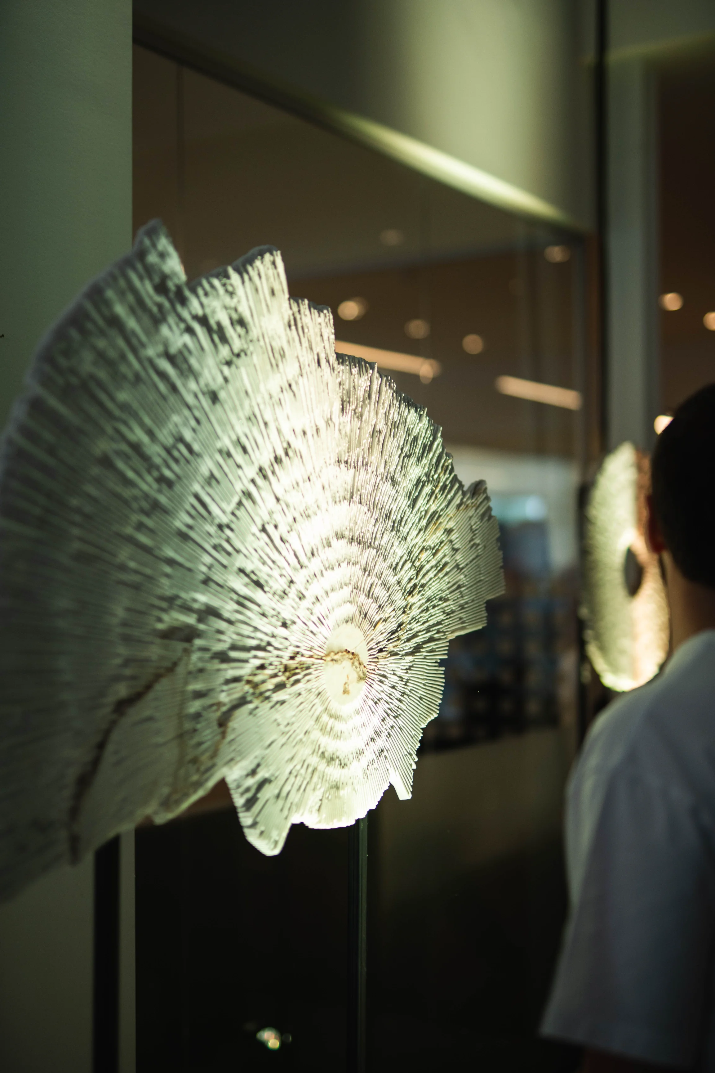 Opera d'arte OCTA - Land Rover realizzata da iStone Arte installata in showroom aziendale durante evento inaugurale, sculture radiali illuminate e pubblico in interazione con le opere