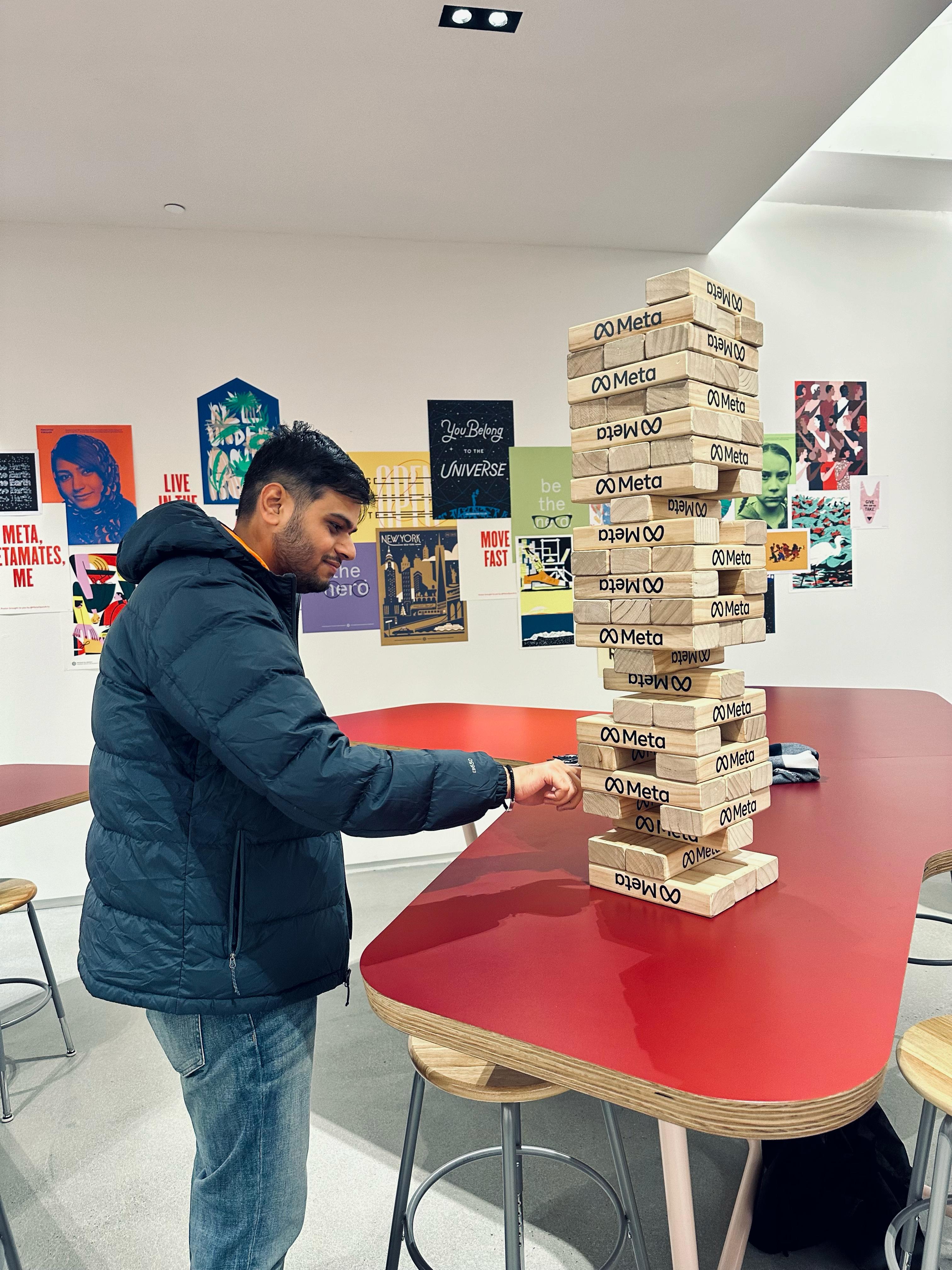 Amish playing with a tower of wooden blocks, demonstrating skill and playfulness in a bright environment.