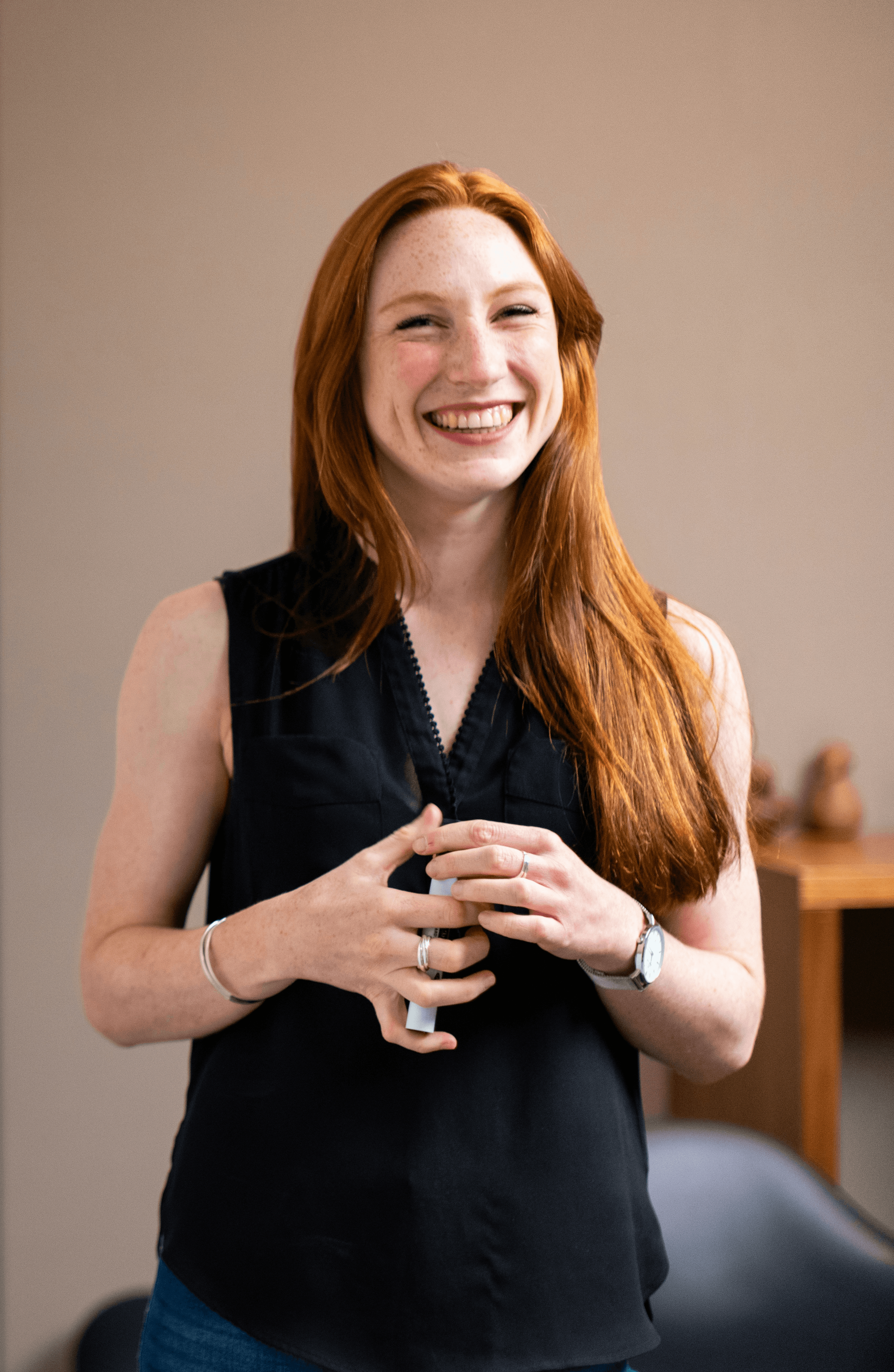 woman in blue tank top standing beside white wall