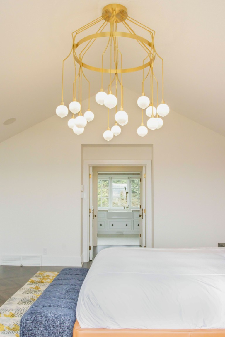 Image of Luxurious bedroom interior with gold chandelier, modern furniture, and spa-inspired bathroom by KHD Homes.