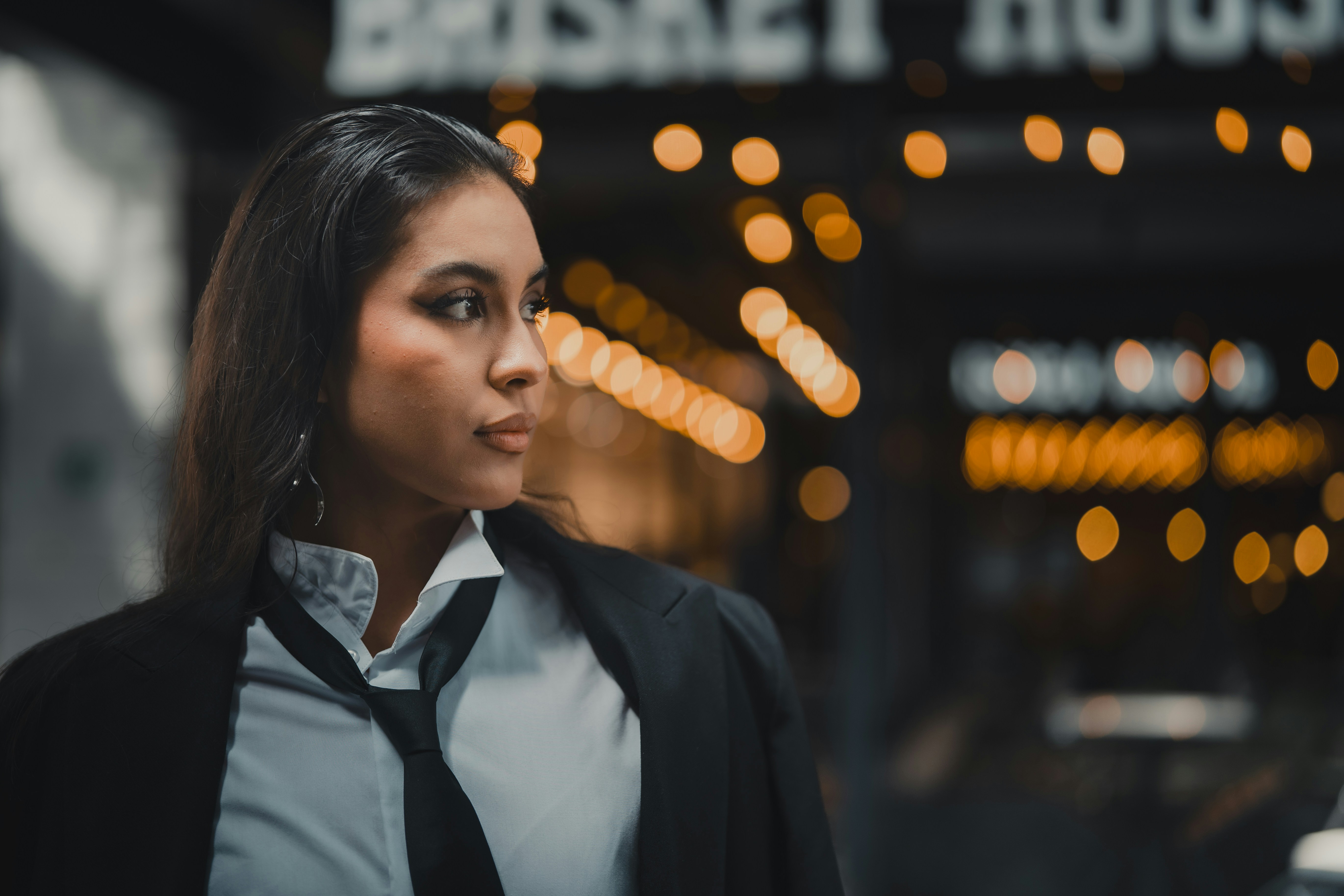 A woman standing in front of a building at night