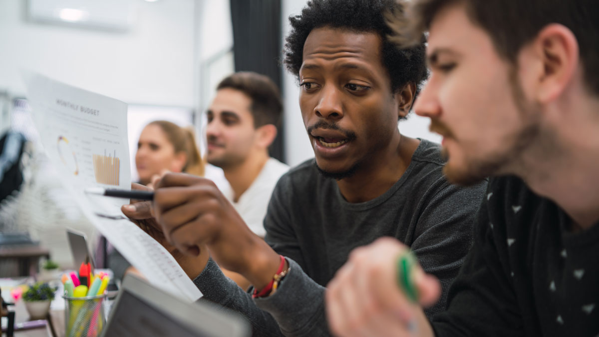 A group of coworkers discussing business outcomes during a strategy workshop 