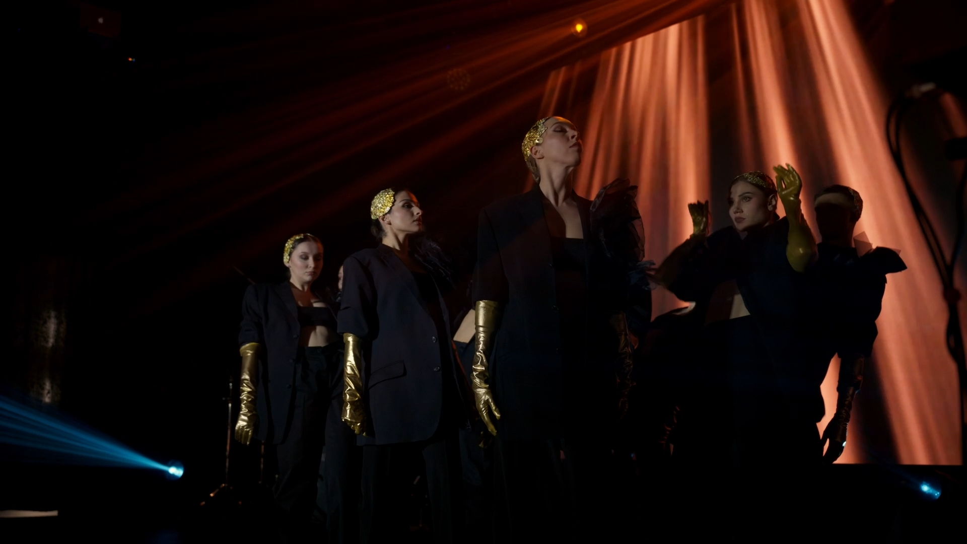 People in black suits on stage