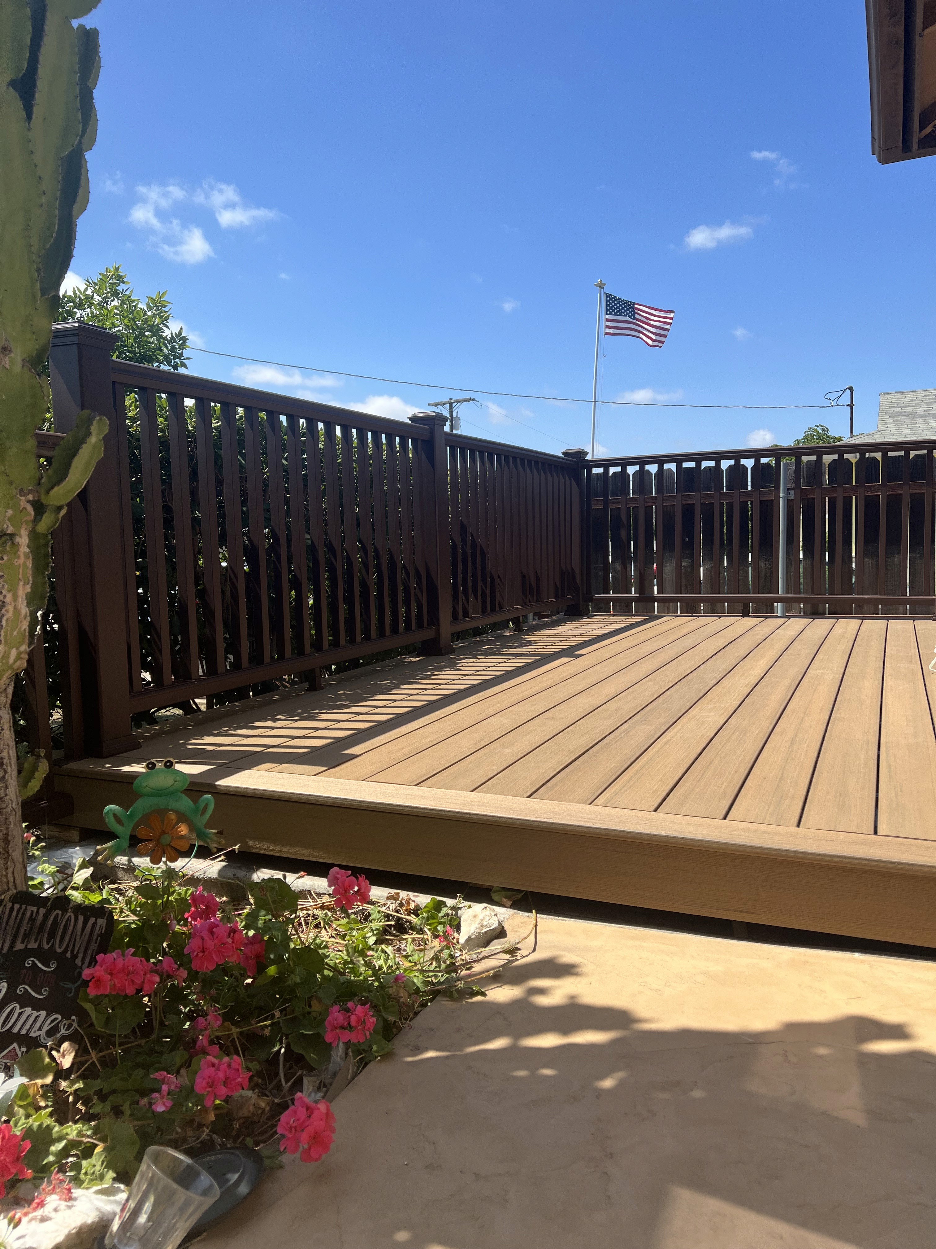 Outdoor deck with dark railing and surrounding landscaping