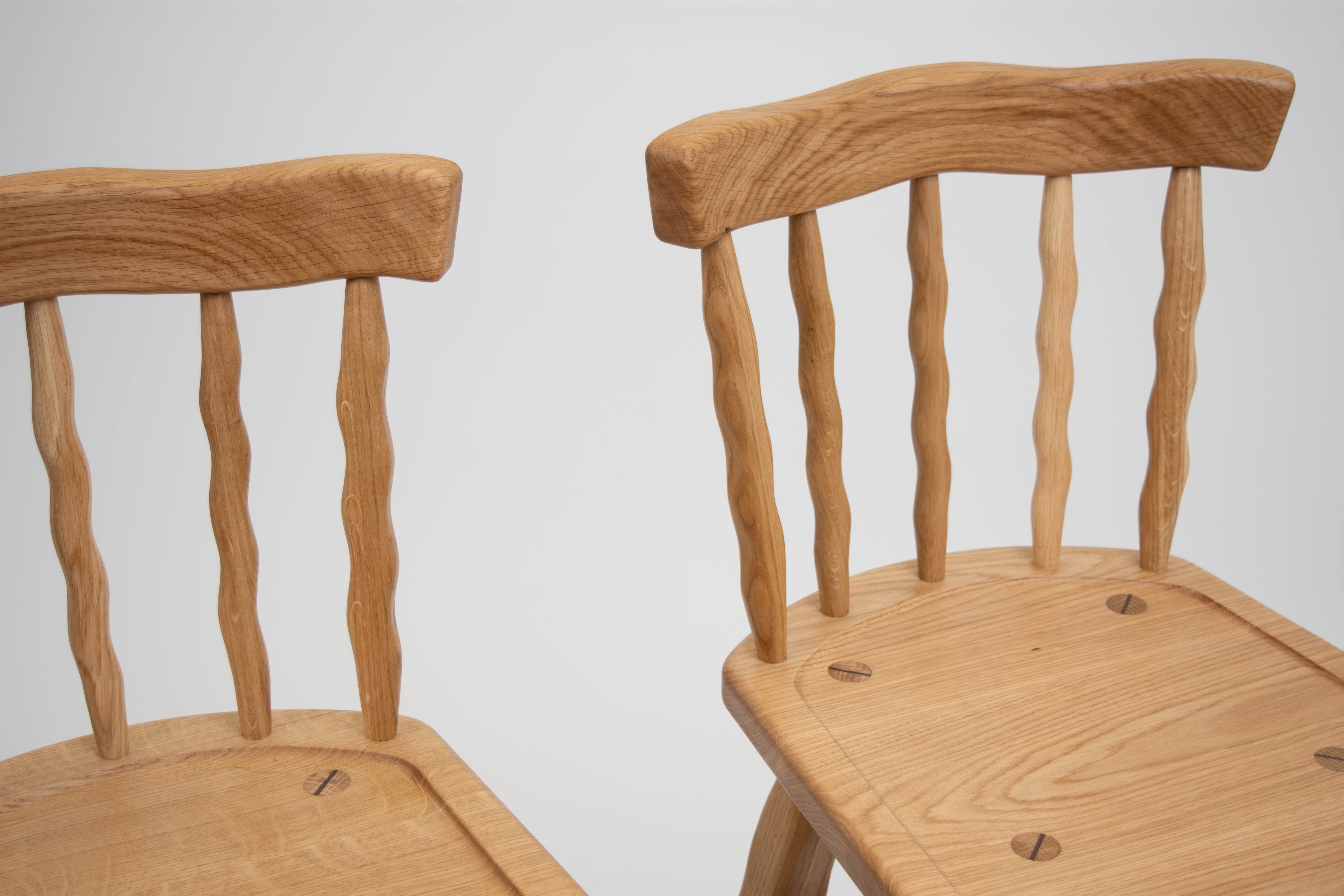 Two Oak chairs with a plain background