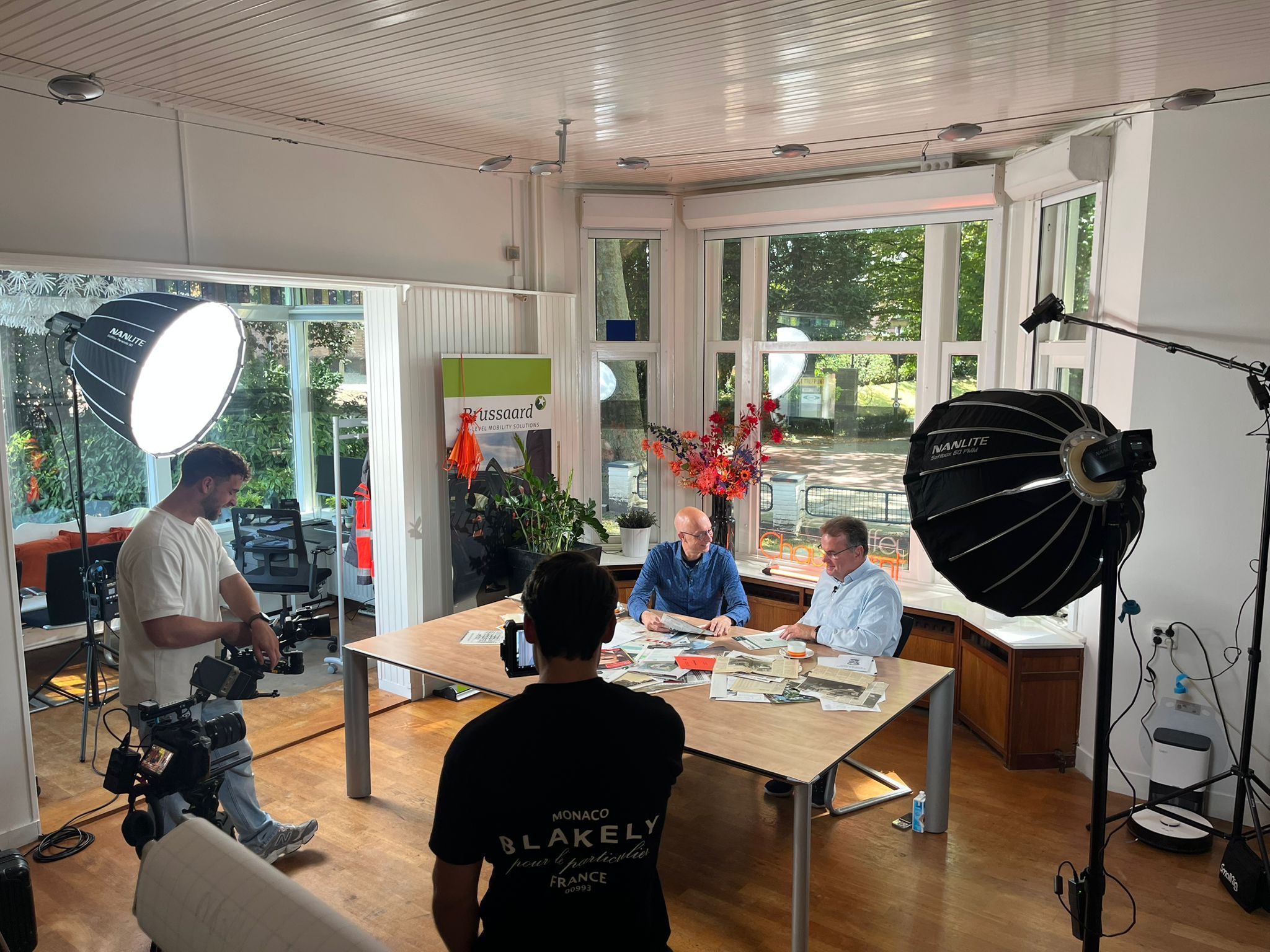 Three people sitting on a couch in a room looking at mobile devices