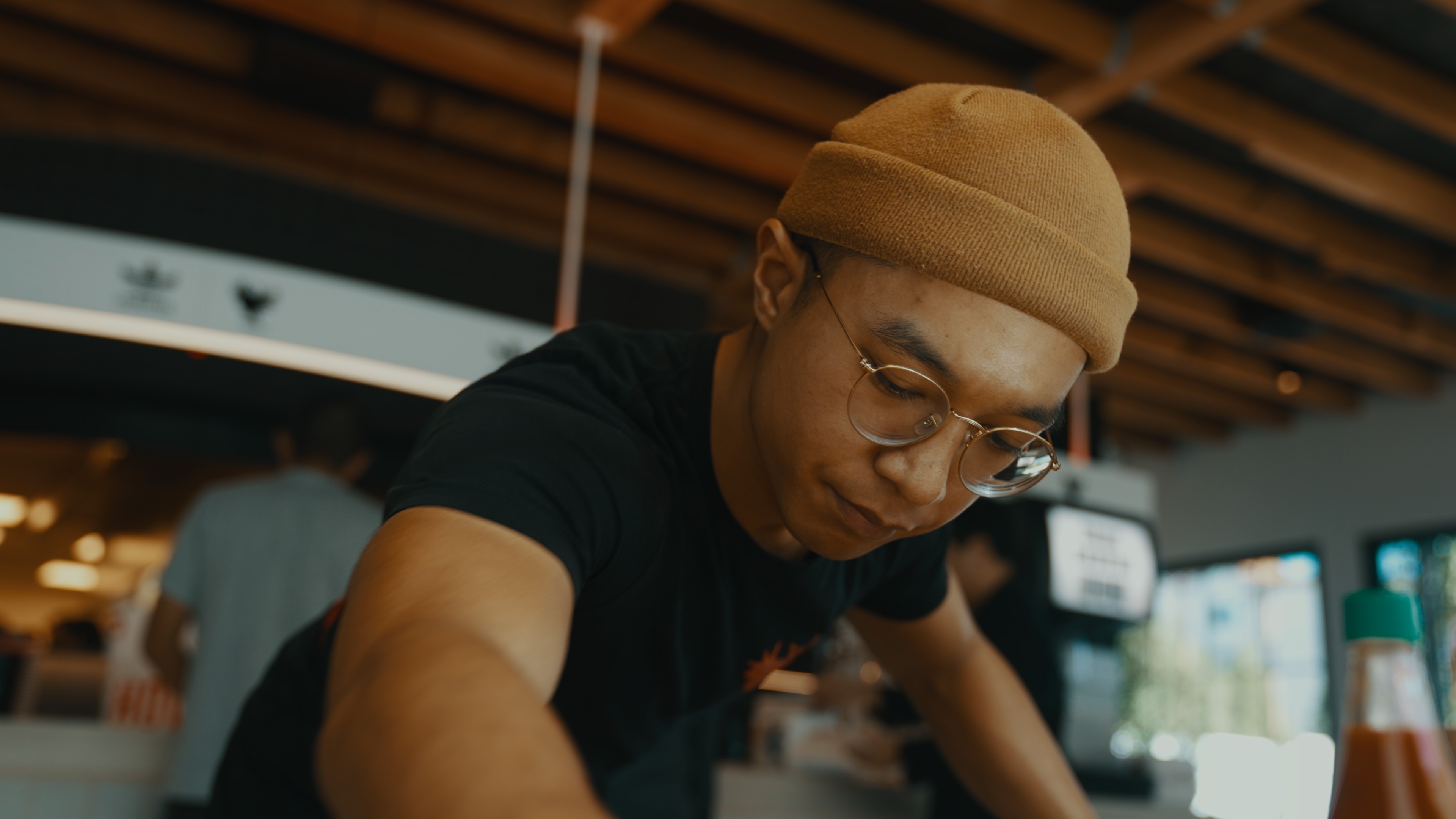 restaurant employee wiping table in howlin rays restaurant in pasadena california