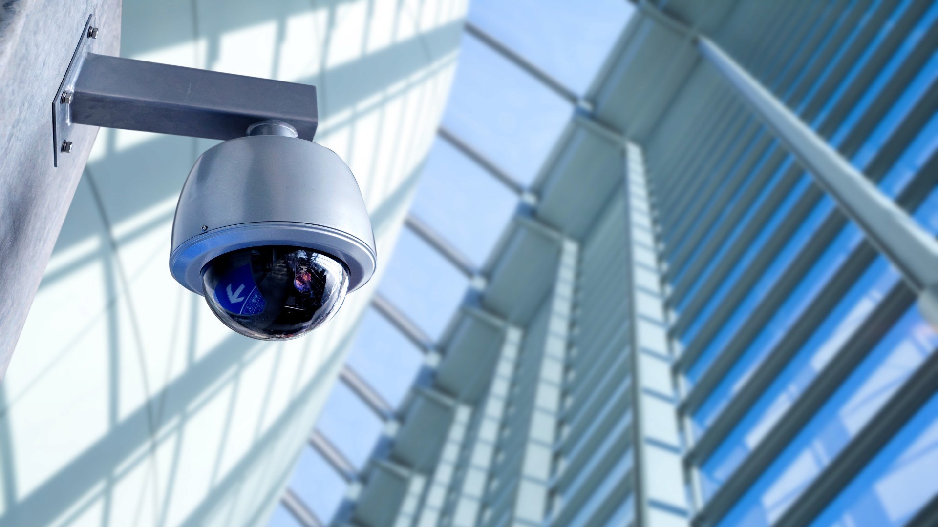 Commercial security camera and access control reader at an office entrance.