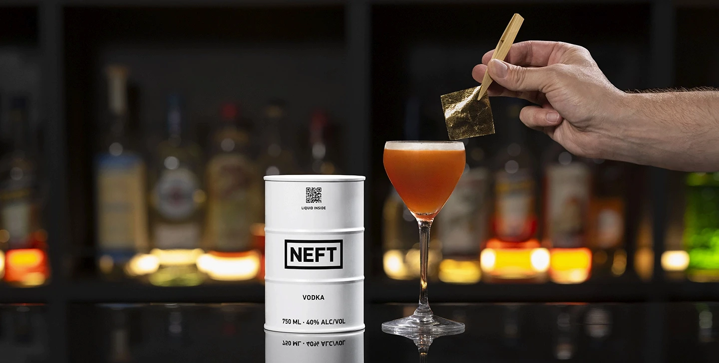 A NEFT Barrel and an 84 Gold martini on a bar counter.
