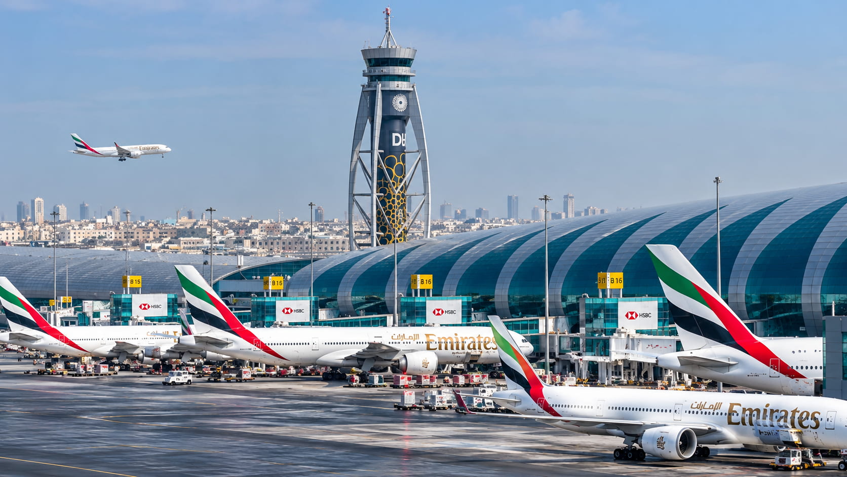 Dubai International Airport (DXB) with Emirates aircraft and an approaching plane.