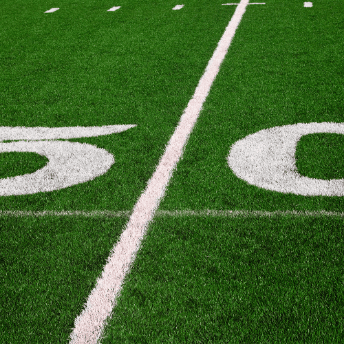man in green 5 American football jersey holding ball