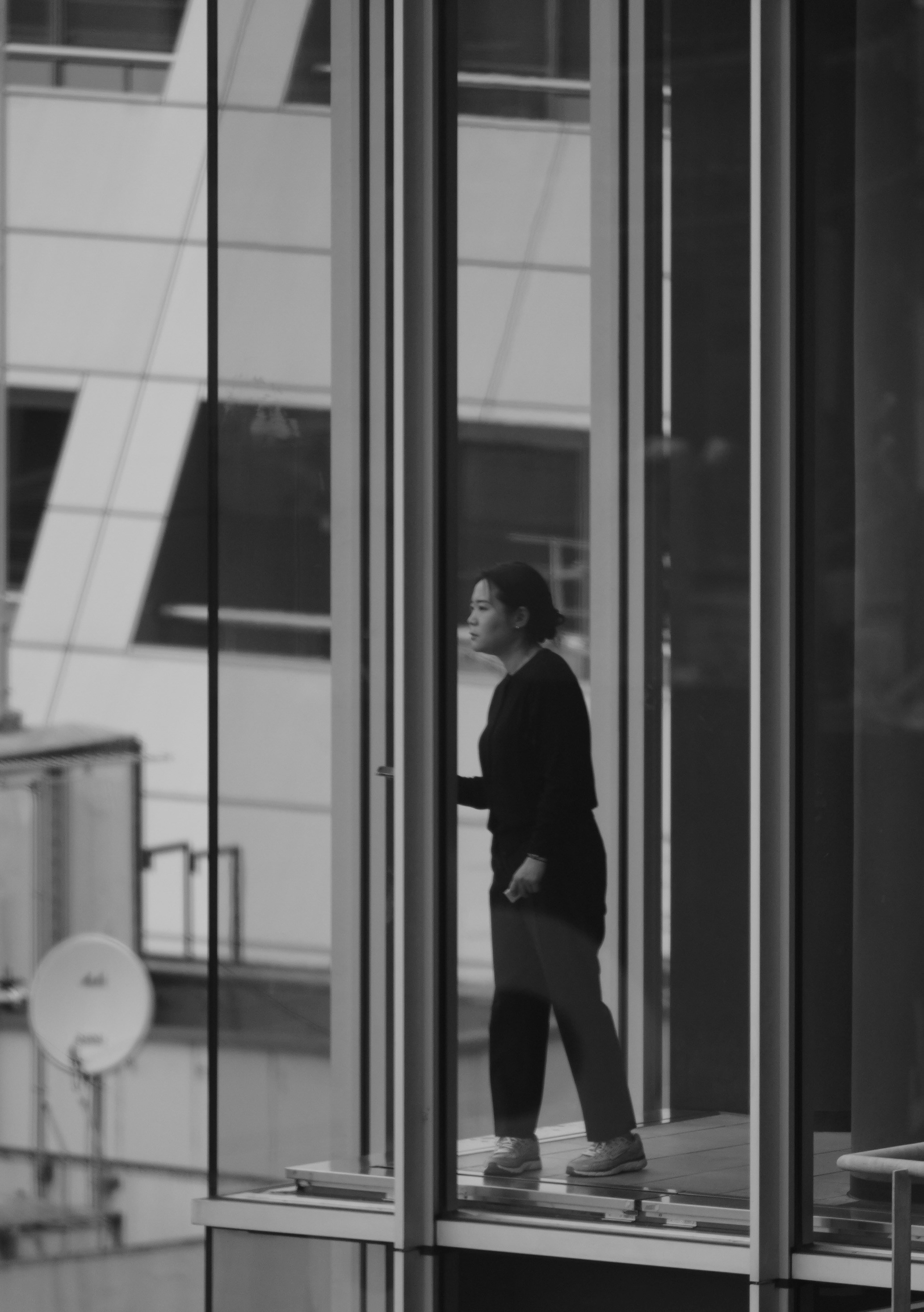 Woman looking out of a modern building window