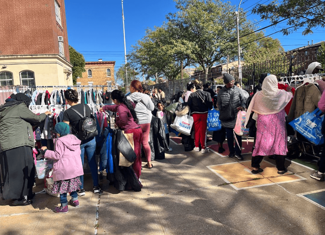 People shop at an outdoor closet for warm clothes. 