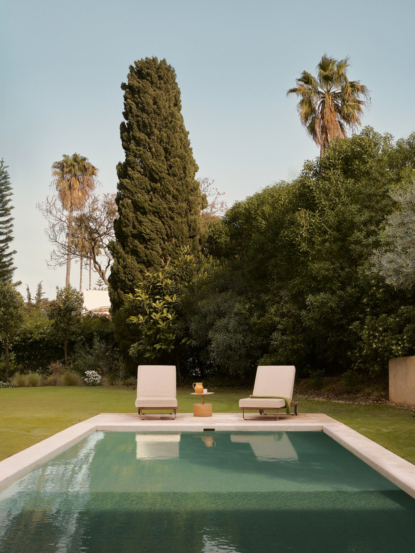 Swimming pool aligned with the architecture and mature Mediterranean landscape.