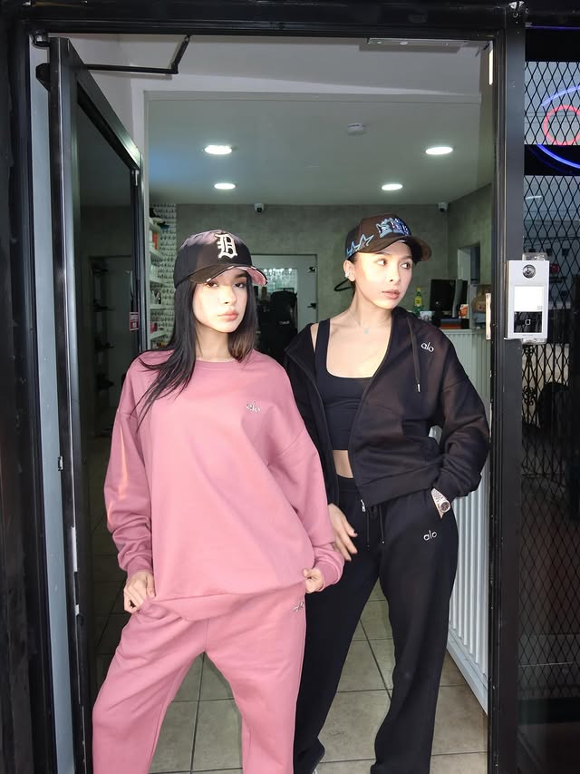 A person's hands adjusting a black ribbon on a white jacket on a mannequin