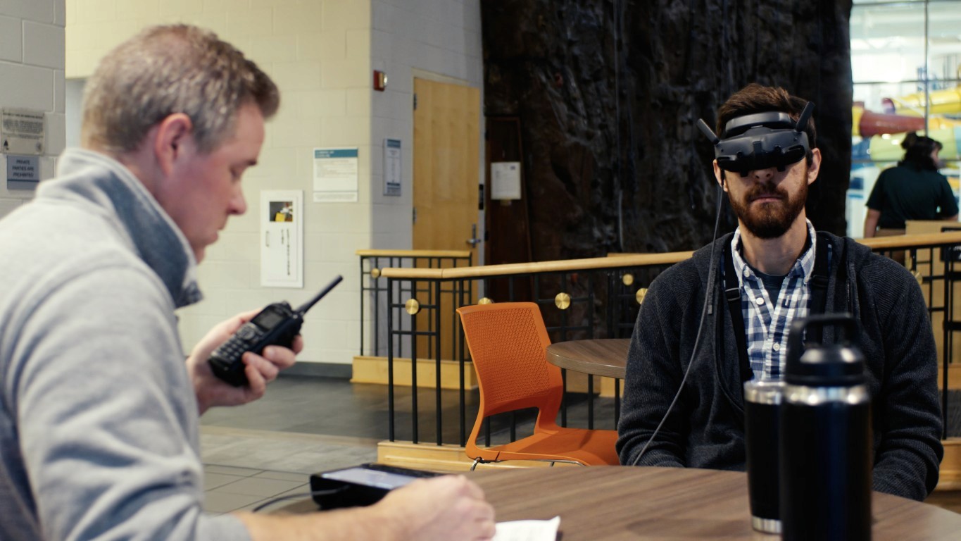 Modern living room with abstract art, beige sectional sofa, indoor plants, and large windows.