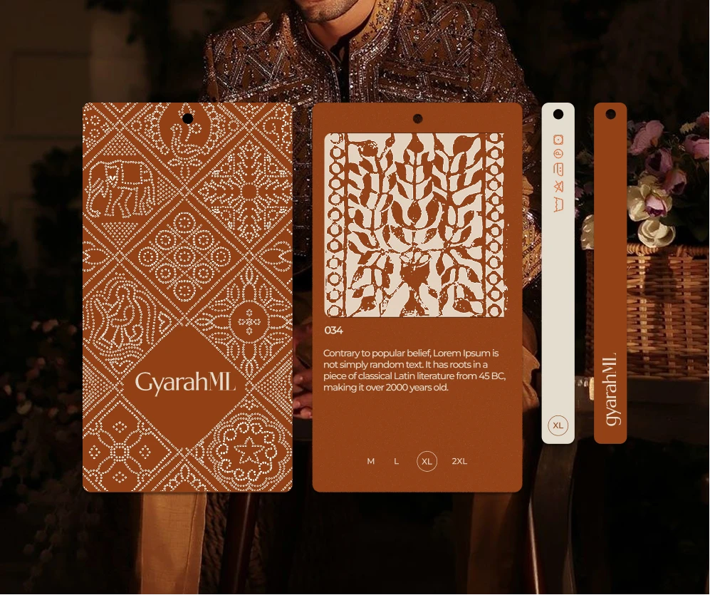 Rust Gyarah ML hang tags with white bandhani-dot motifs of elephants and flowers, a block-print card, size options and care strips, over a man in an embroidered sherwani.