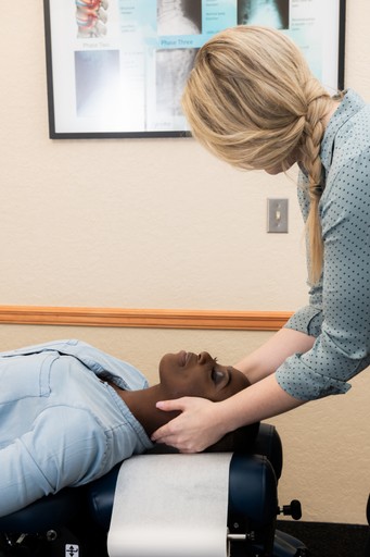 quiropráctico ajustando el cuello de un paciente