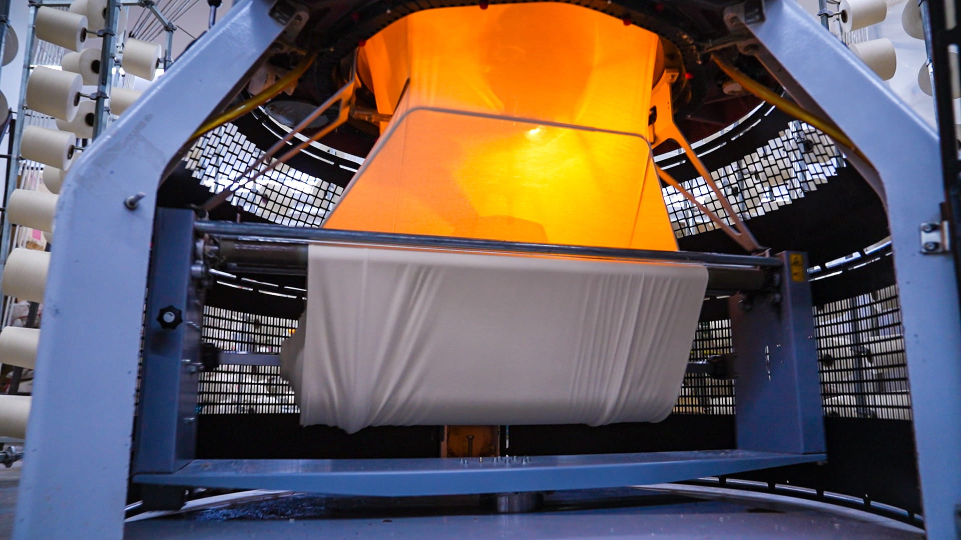 Knitting machine producing fabric.