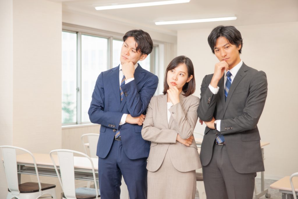 3人並んで悩んでいる会社員